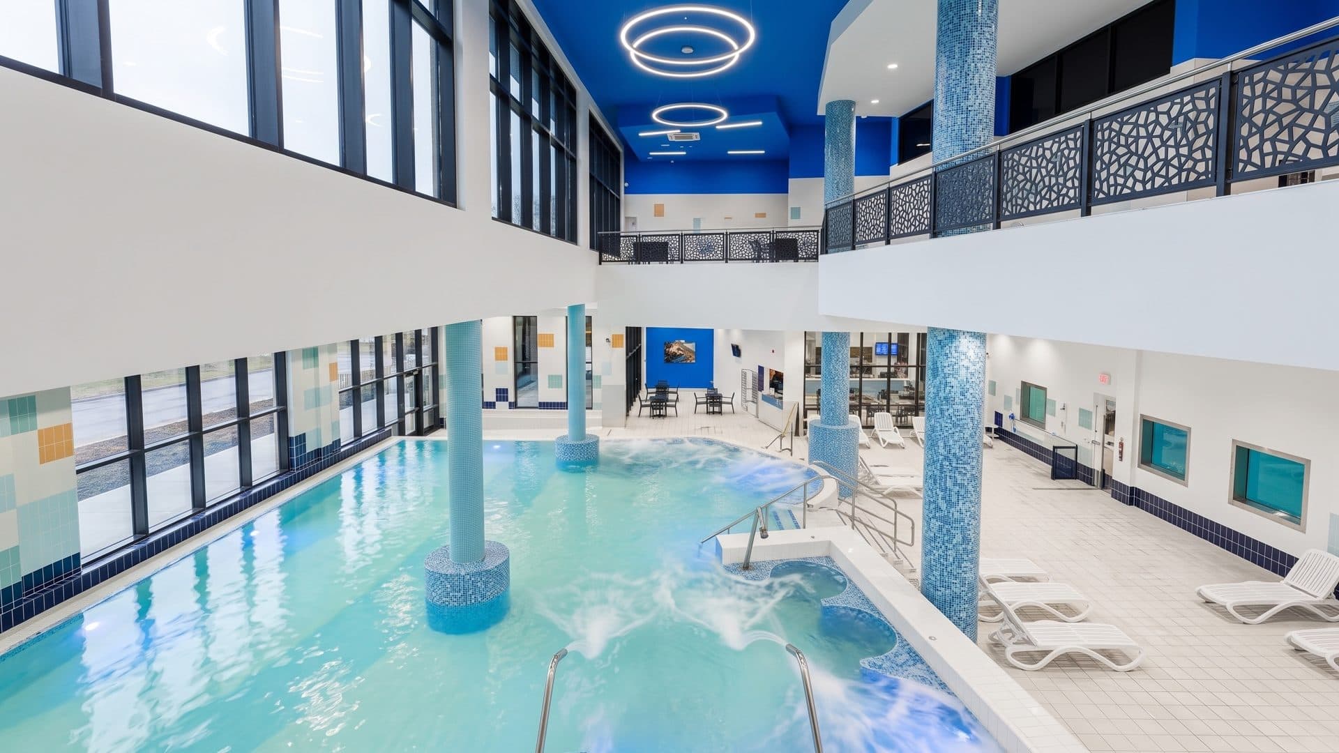The indoor thermal pool of Adica Wellness Centar with mosaic columns, water jets and a blue-lit ceiling