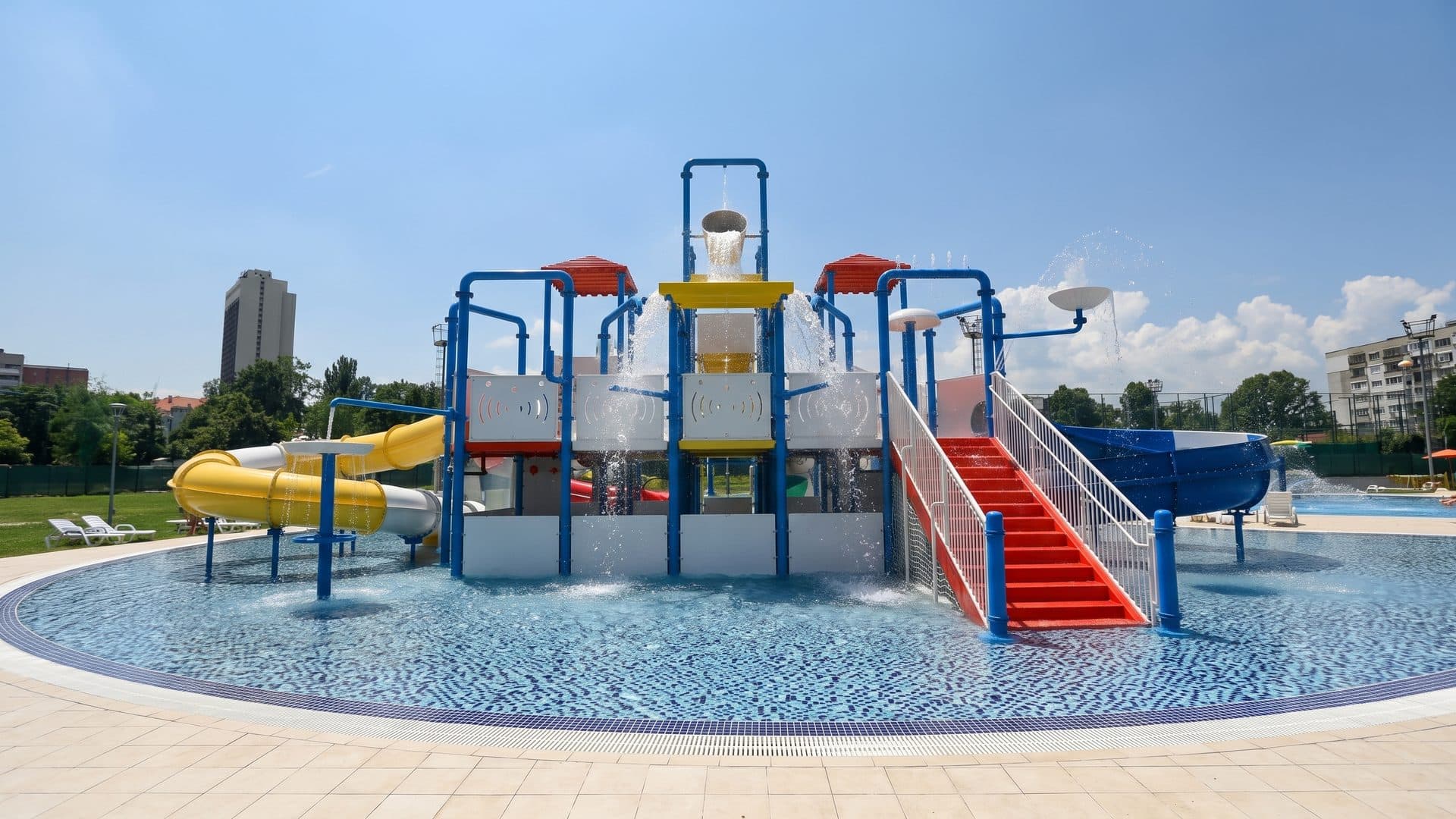 The splash pad of the Vazrazhdane water park with its tipping buckets above the shallow pool