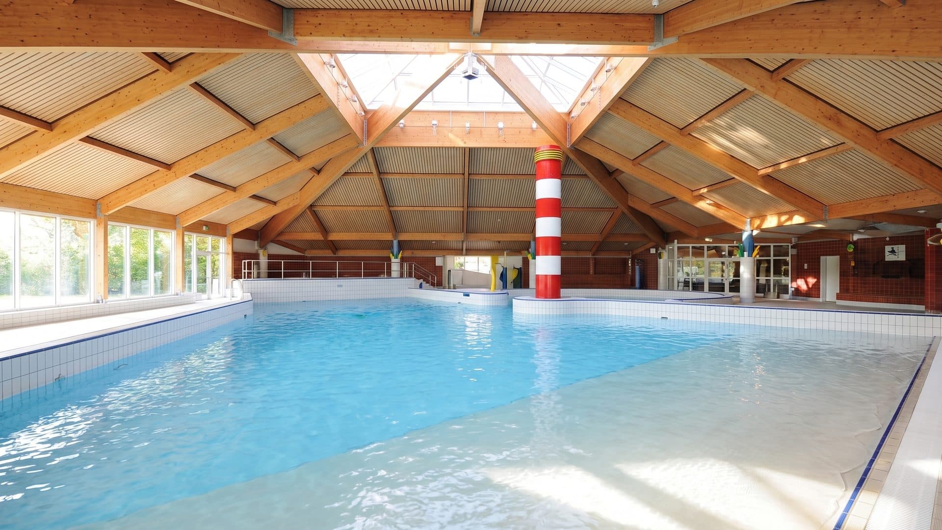 The wave pool of the Amrum Badeland below its striped lighthouse tower