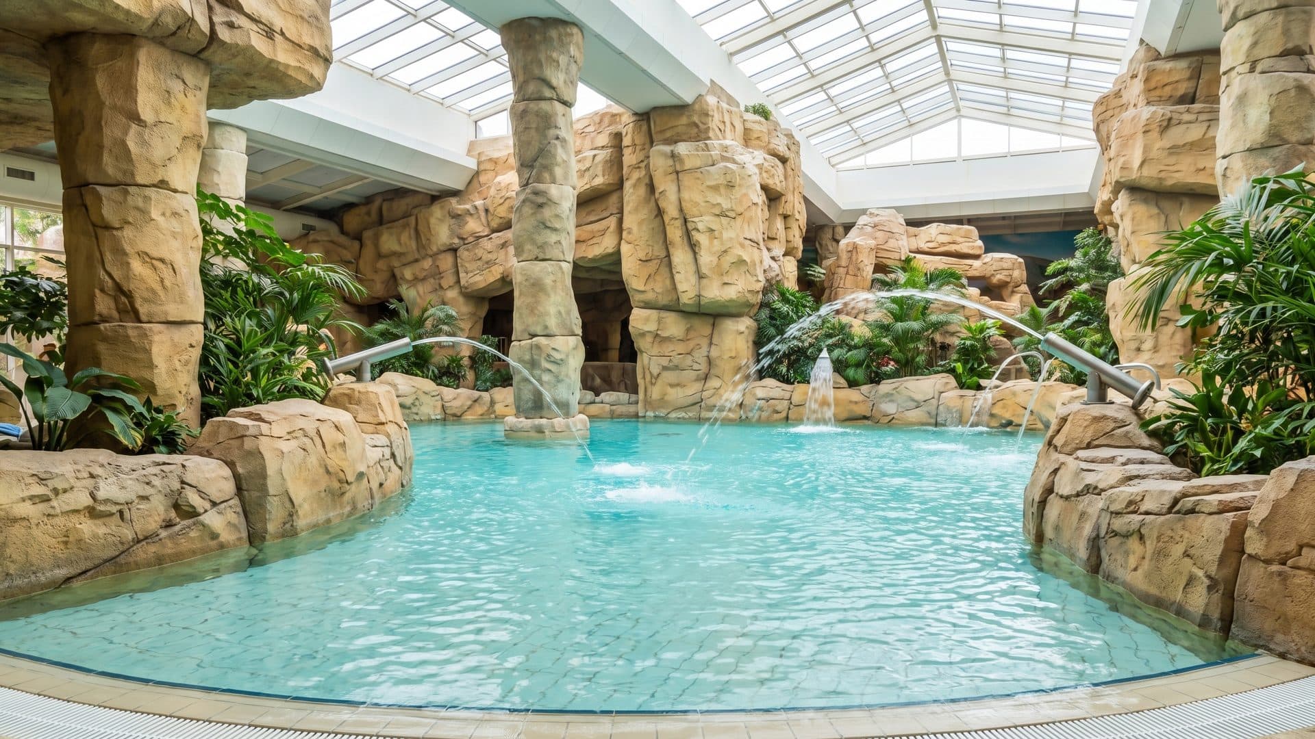 The water play zone of Aqua Mundo among its sandstone rocks under the glazed roof
