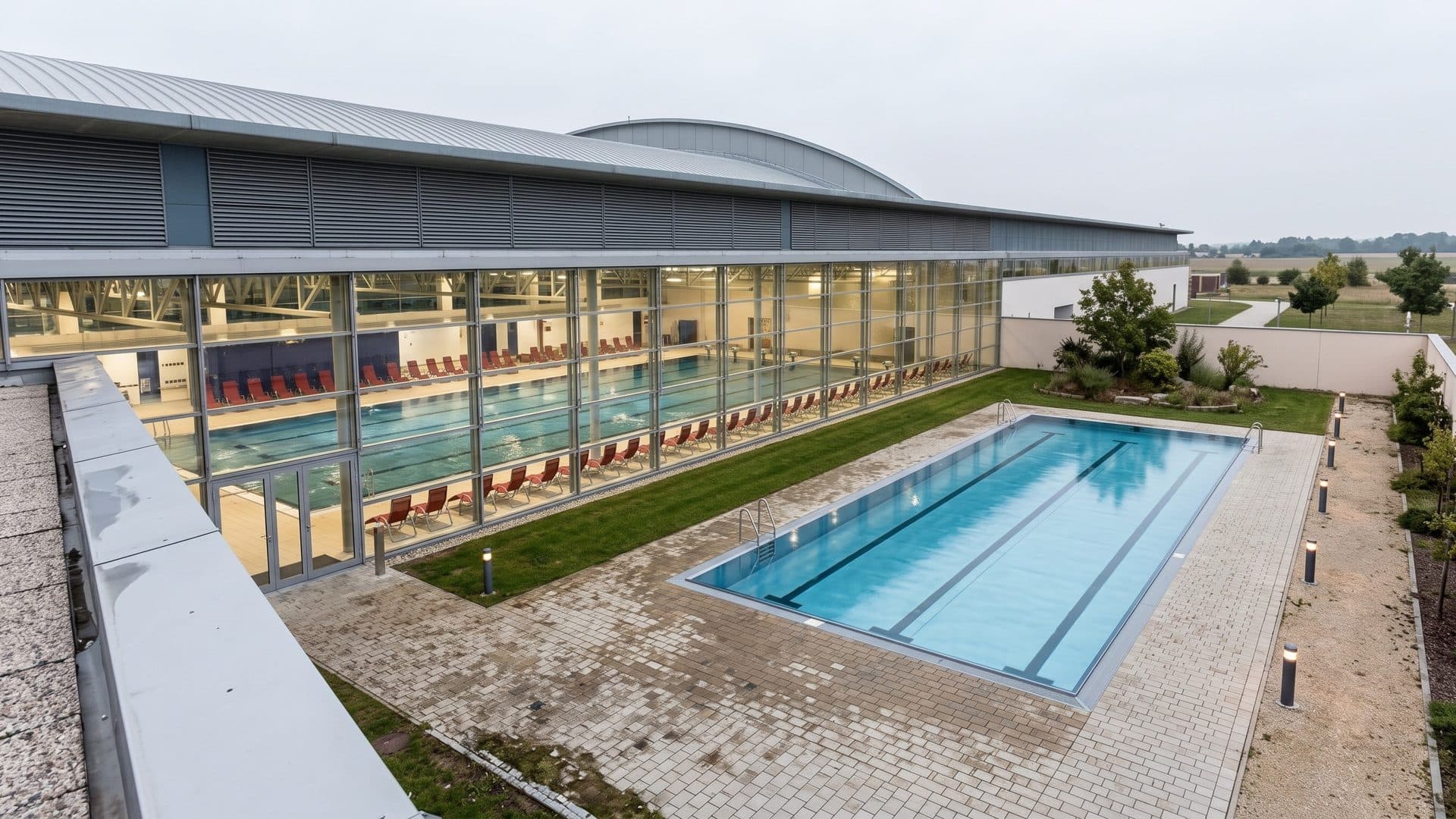 The outdoor pool of Aqua Nova in Wiener Neustadt in front of the long glazed swimming hall
