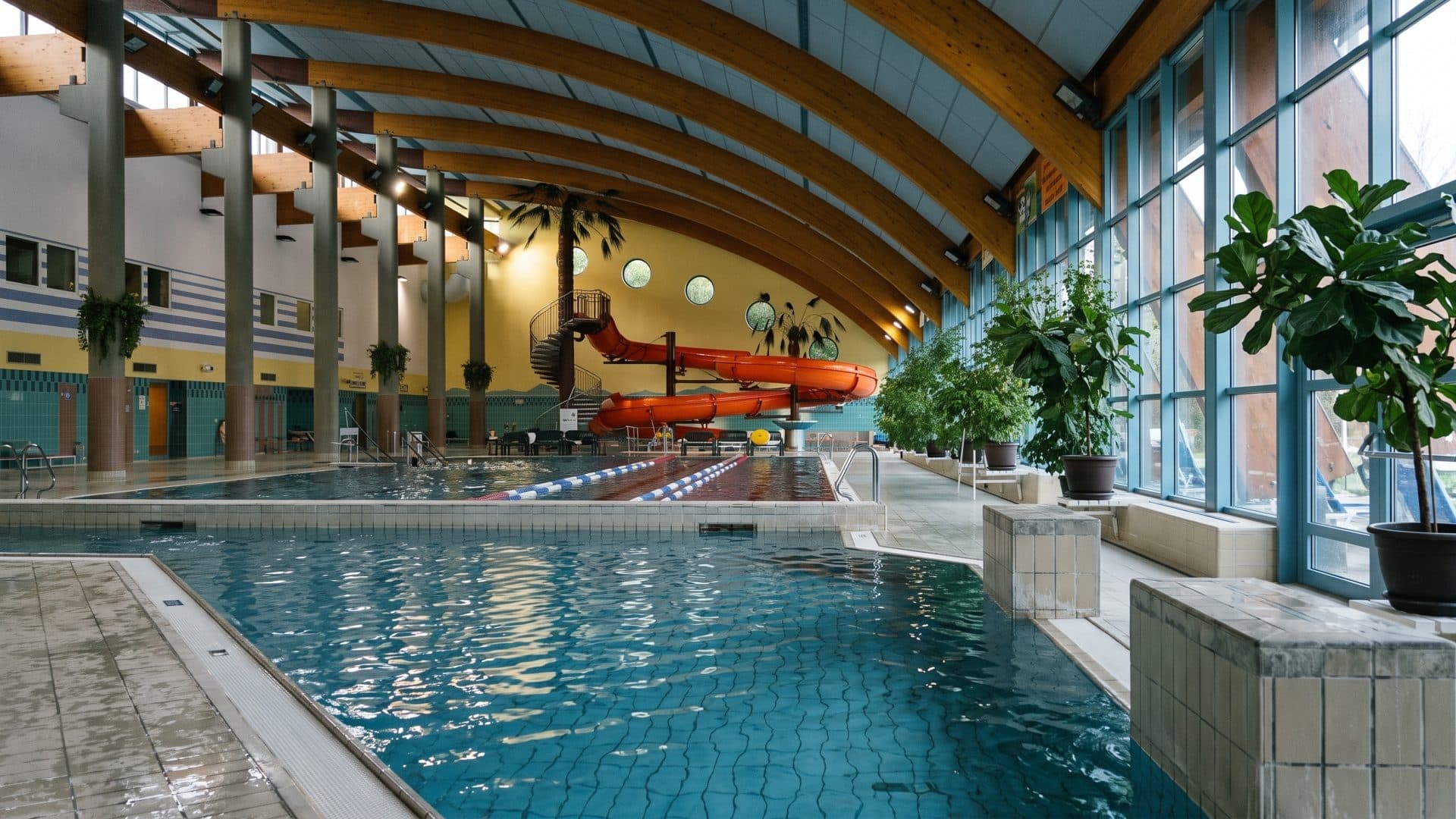 The lane pool of the Aquacentrum in Bohumin under timber arches, an orange slide at the far end