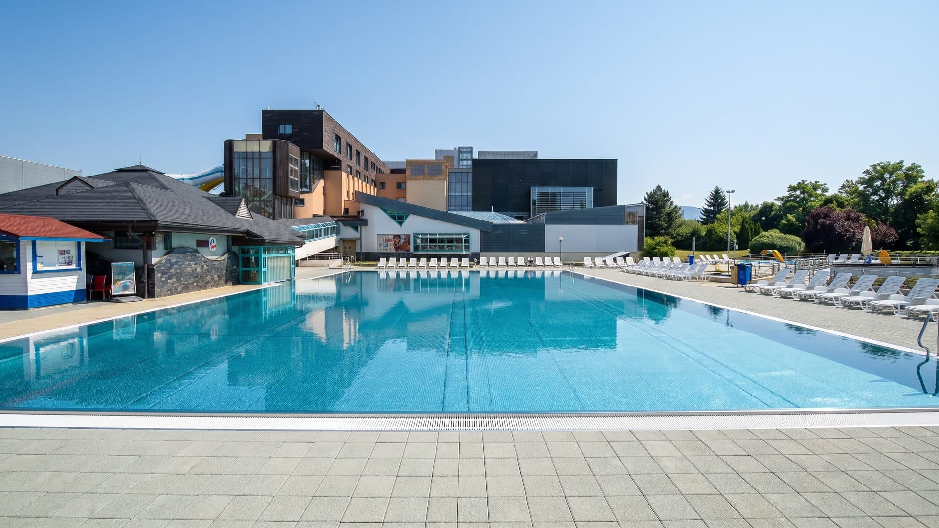 The outdoor pools of Aquacity seen across the water with the bath buildings behind