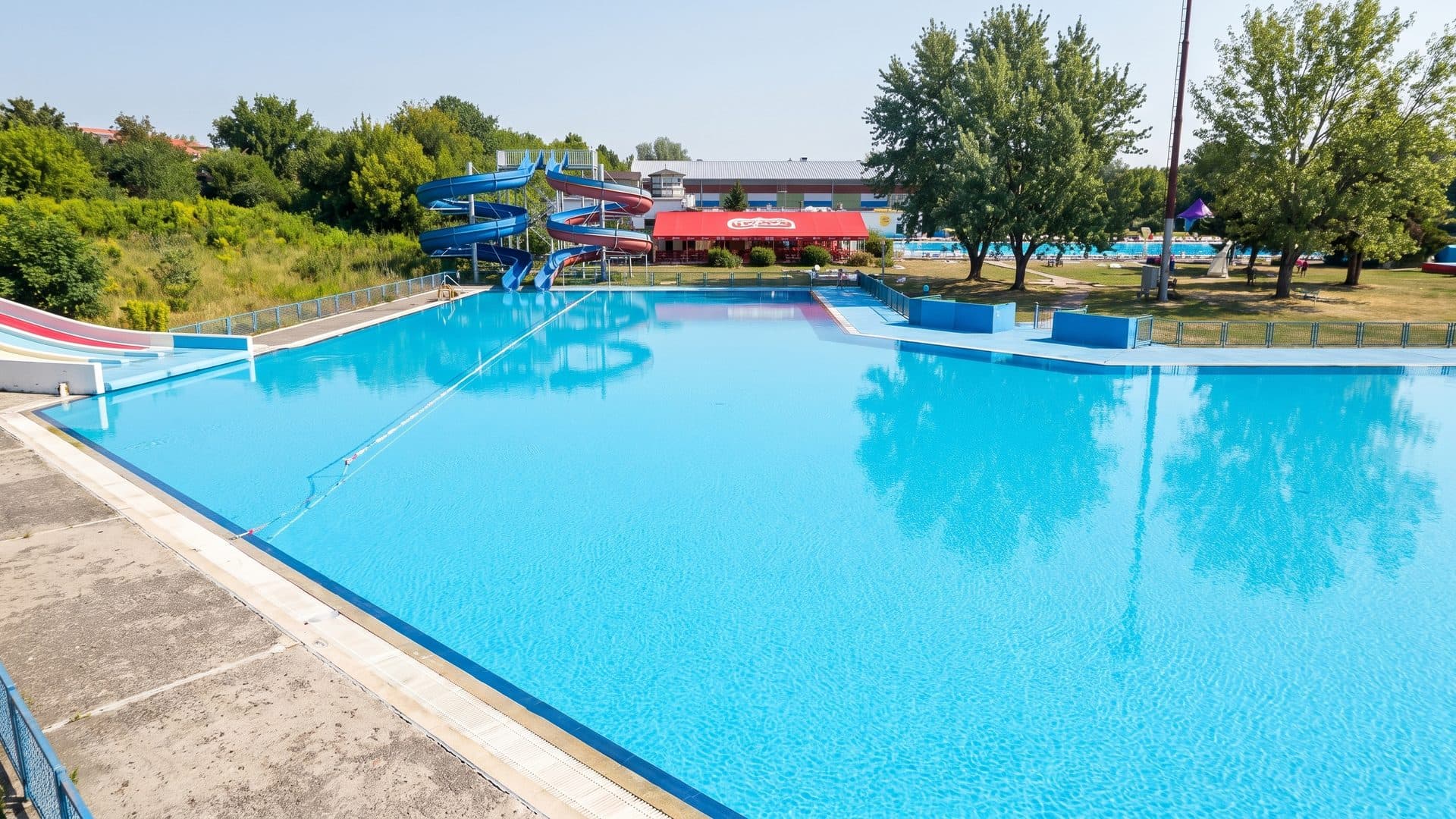 The outdoor pool of Aqualand Banska Bystrica seen across the water from the deck