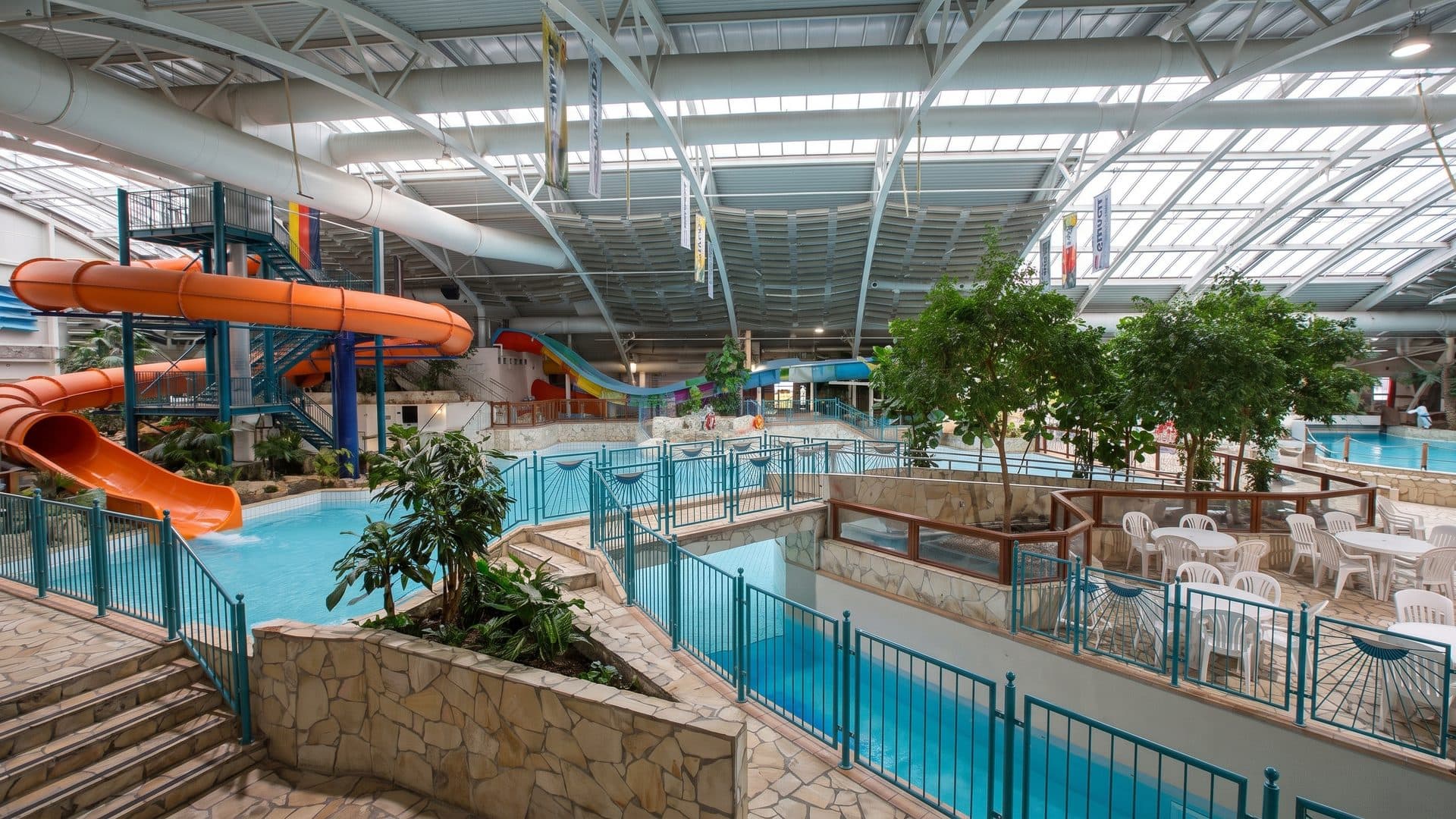 The hall of the Aquana baths with its orange slide above the pools and planting