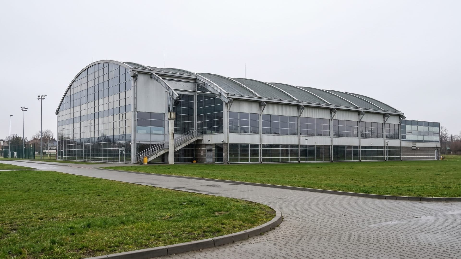 The curved glazed front of the Granit water park with the lawn and paths in front
