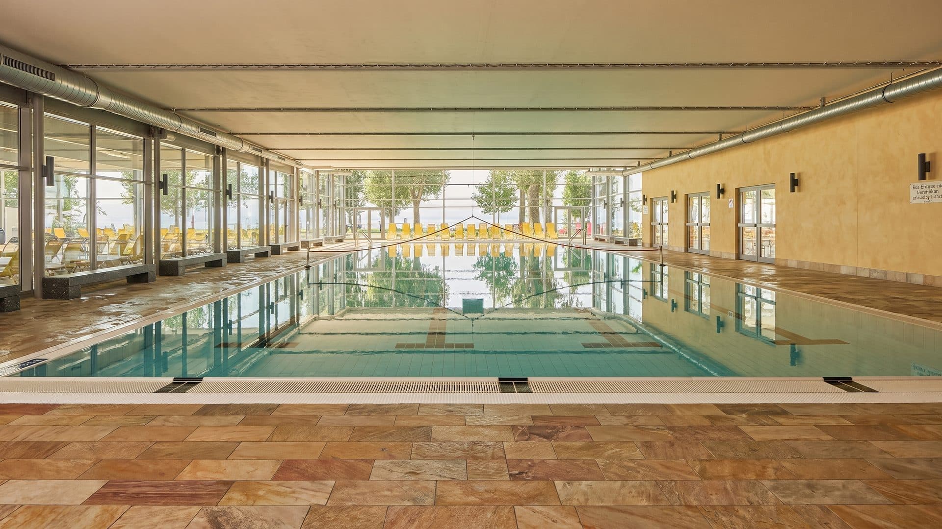 The indoor pool of Aquastaad seen down its length between the coloured walls