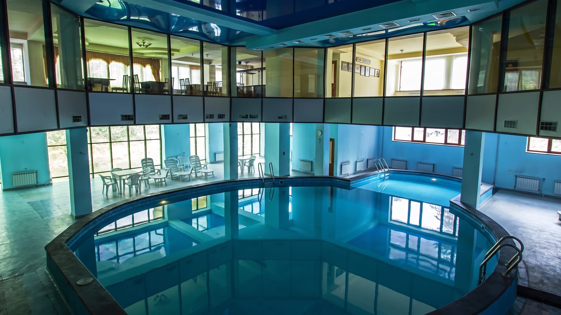 The circular indoor mineral-water pool at the Arzni resort, ringed by a two-storey glazed gallery