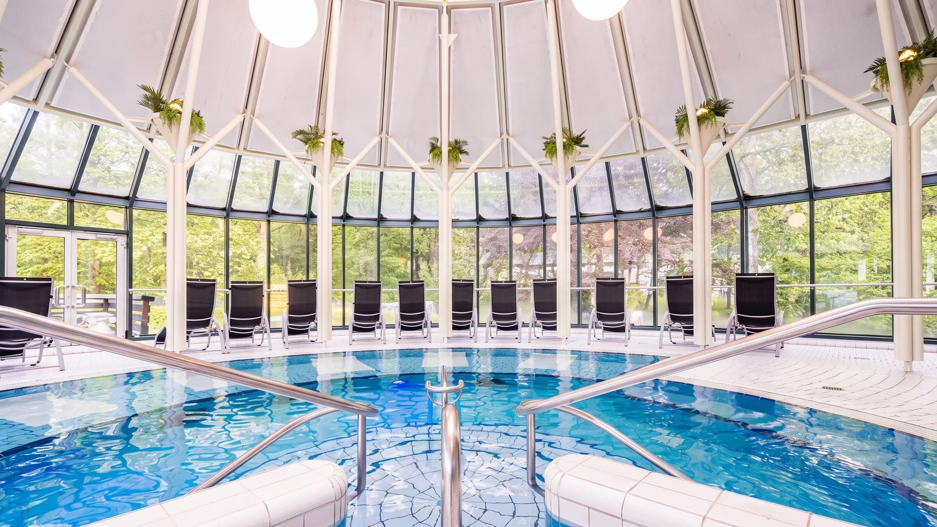The glazed conservatory pool at the Sole-Therme in Bad Harzburg, ringed by loungers under a domed roof.
