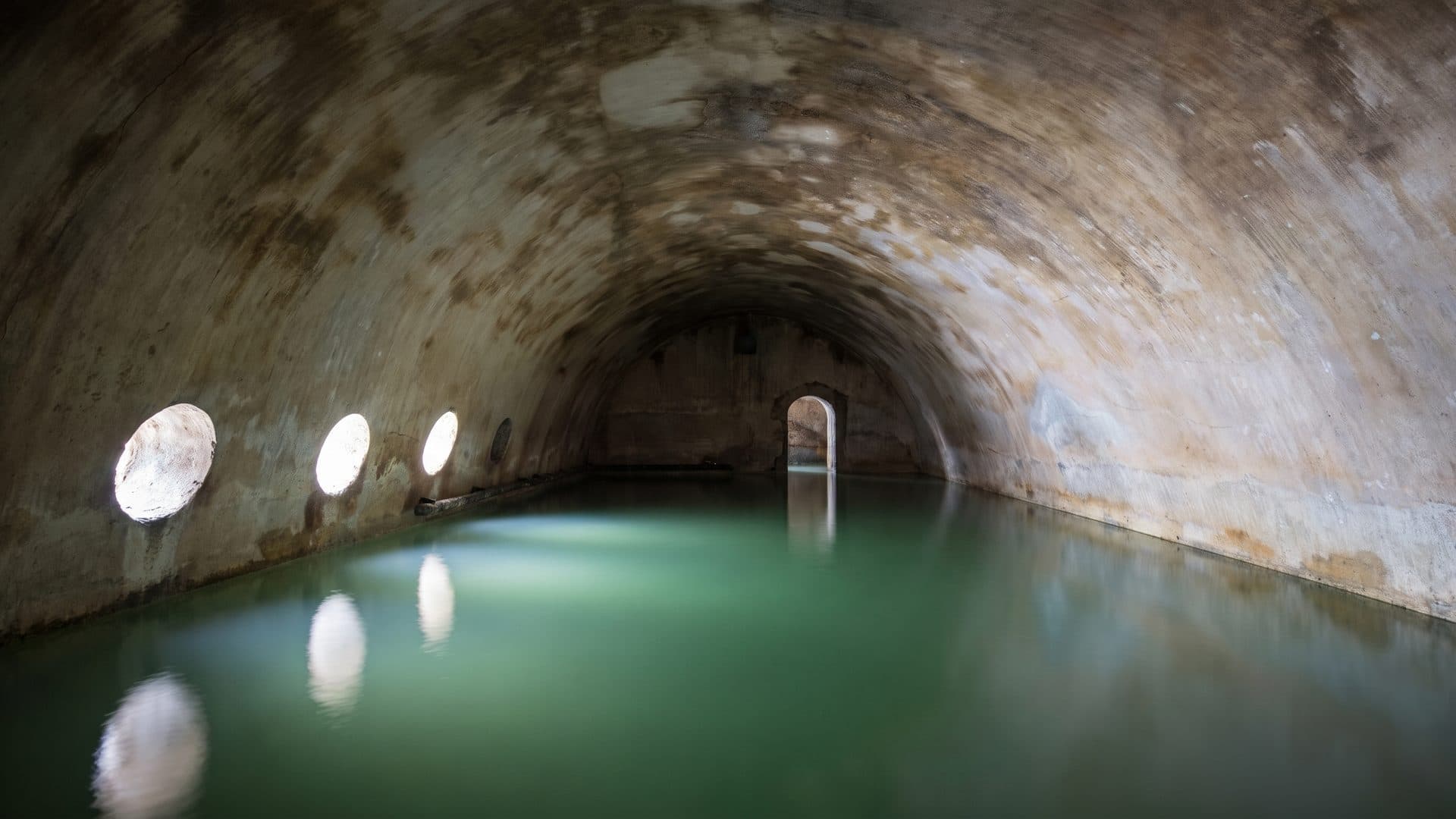 The vaulted stone reservoir of the Bad zum Raben holding its thermal water