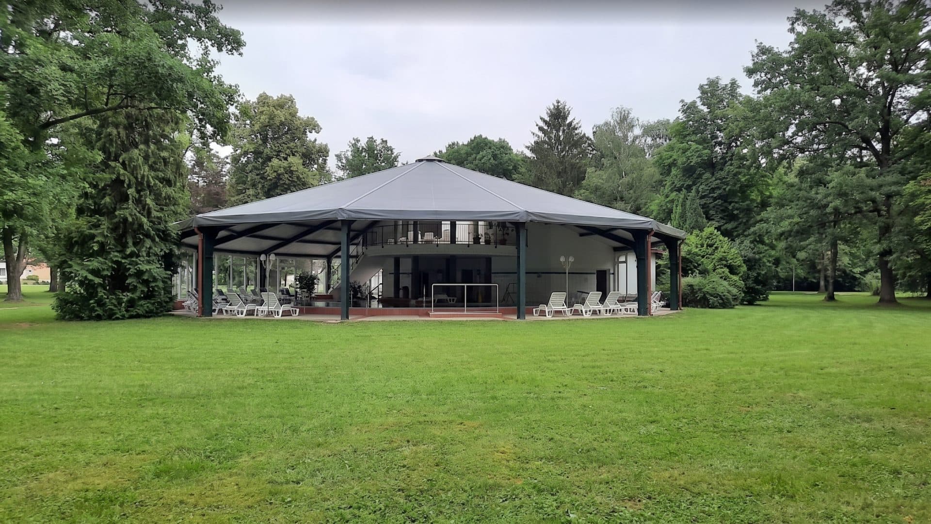 The covered thermal pool of the Banfurdo baths seen from the lawn outside