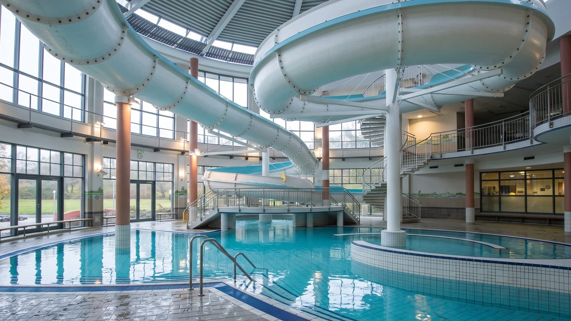 White tube slides curving over the indoor pool of the BEECH Aquafun in Gohren-Lebbin
