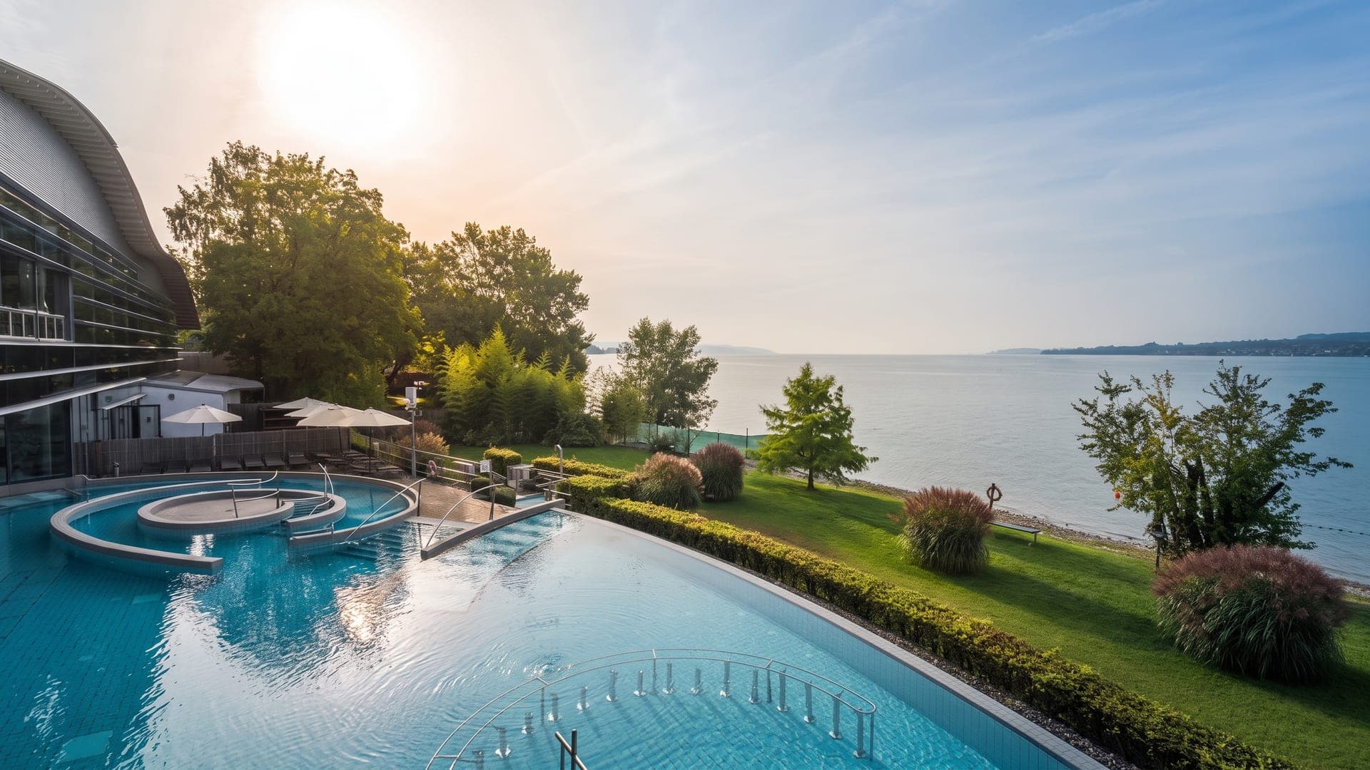Outdoor pool looking out over the lake through trees in low sun