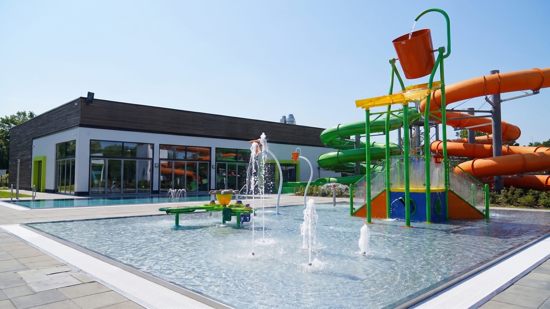 The outdoor family pool of CabrioLi with its tipping bucket tower, green slides and water jets