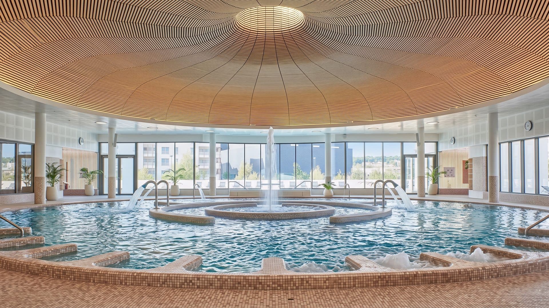 The spa hall of Caliceo under its circular timber roof above the fountain pools