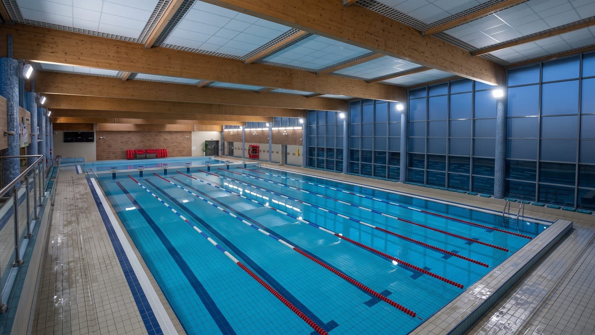 The indoor lane pool of the Ilawa leisure centre under timber beams and a tall glass wall