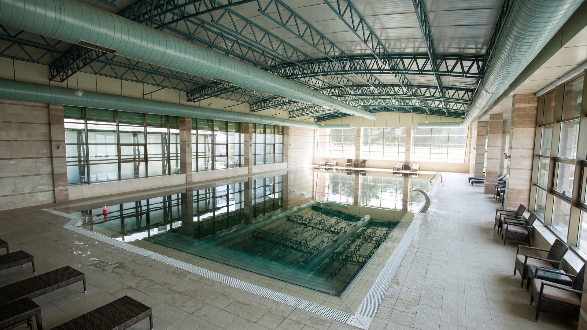 The long indoor pool at Chinar in Naftalan in its steel-trussed hall with full-height glazing