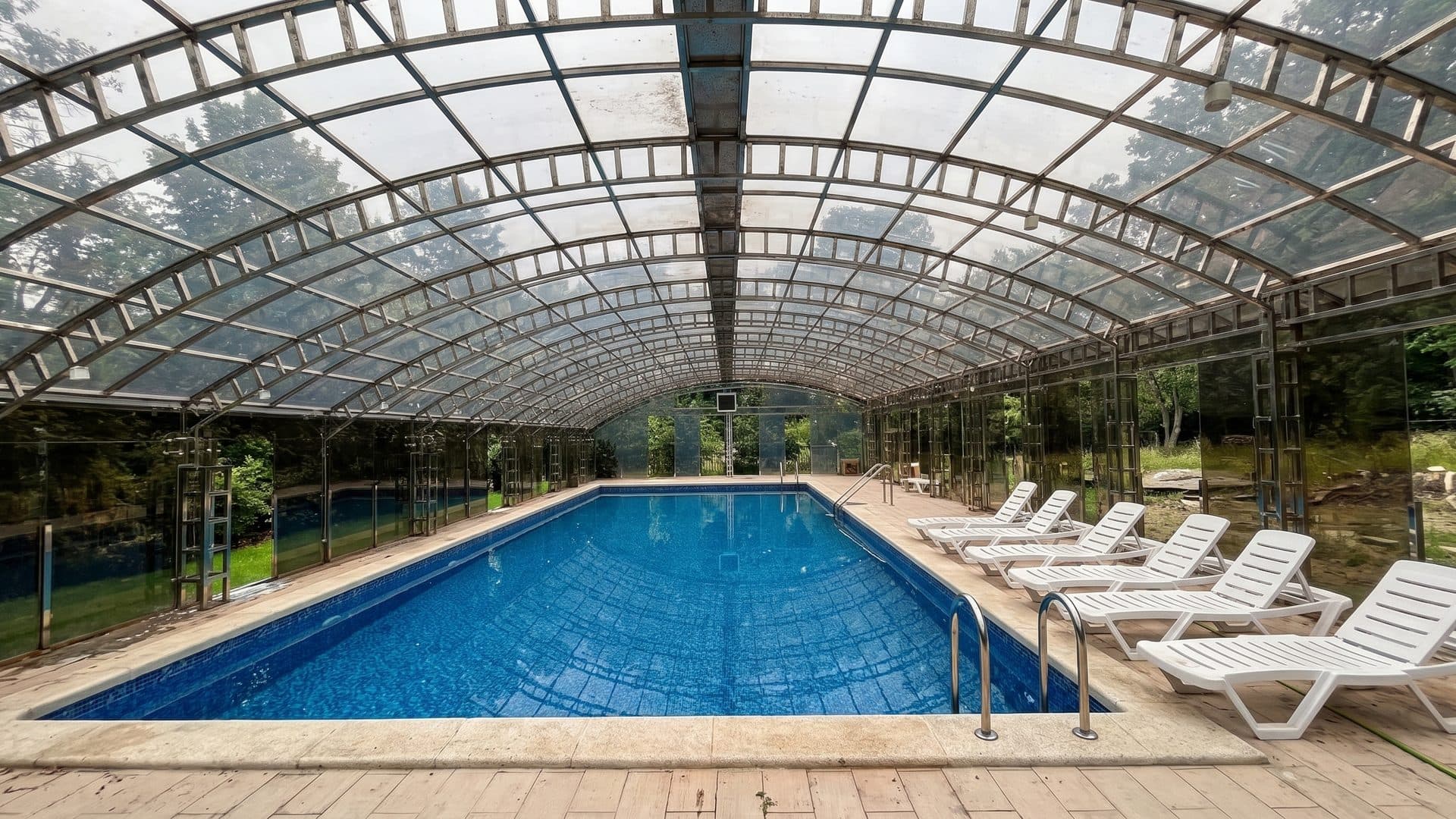 The pool at the Chortoq sanatorium under a barrel-vaulted glazed cover, with loungers in a row alongside