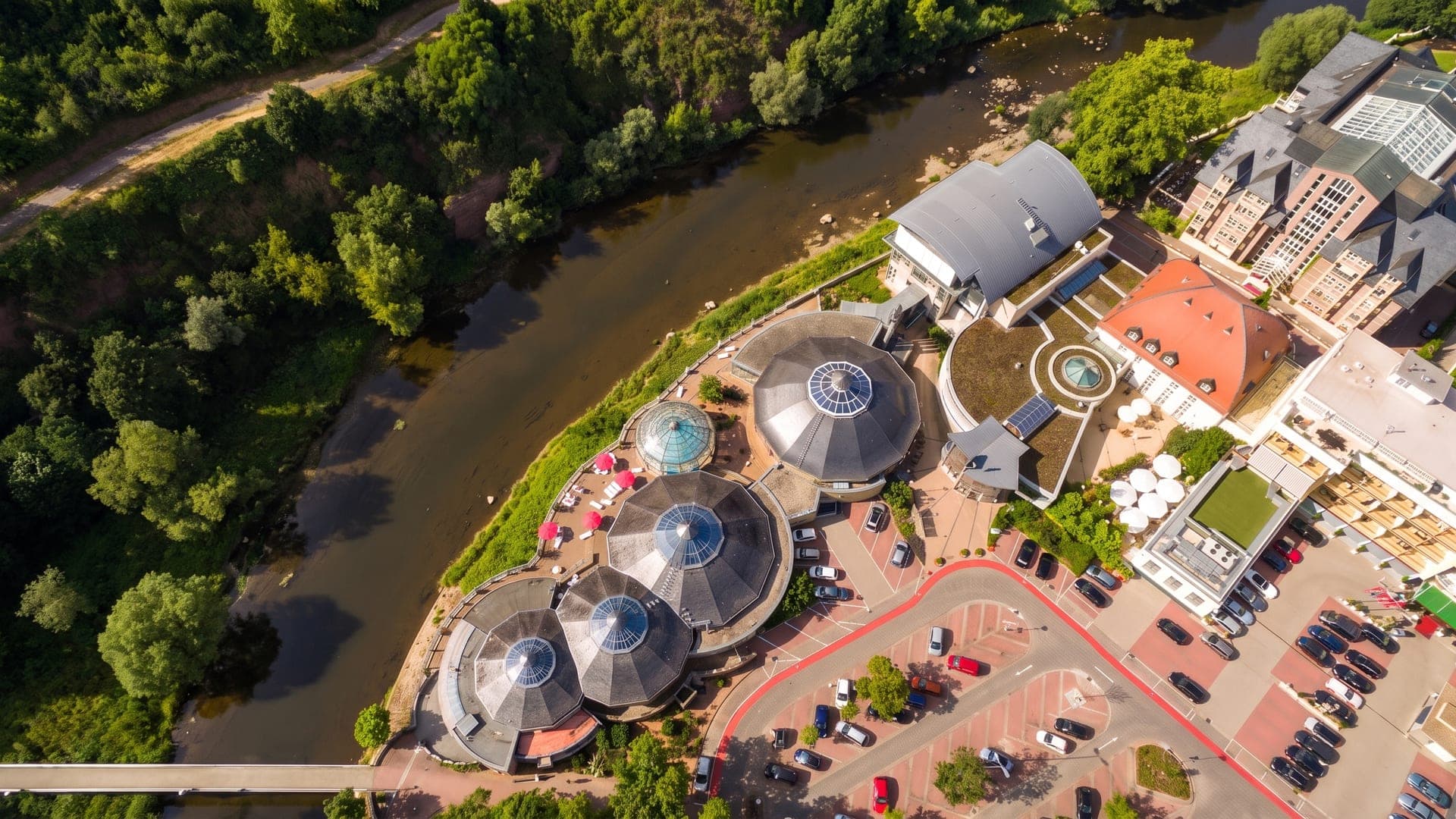 Aerial view of the domed pool buildings on a bend of the river