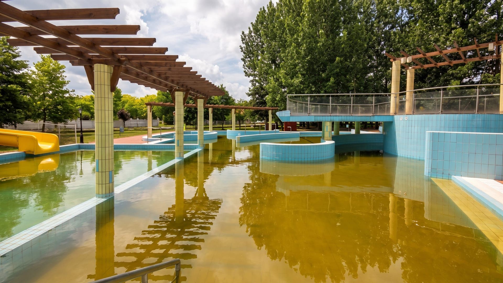 The outdoor pool at the thermal bath in Davod, its pergolas and tiled walkways above the green thermal water.