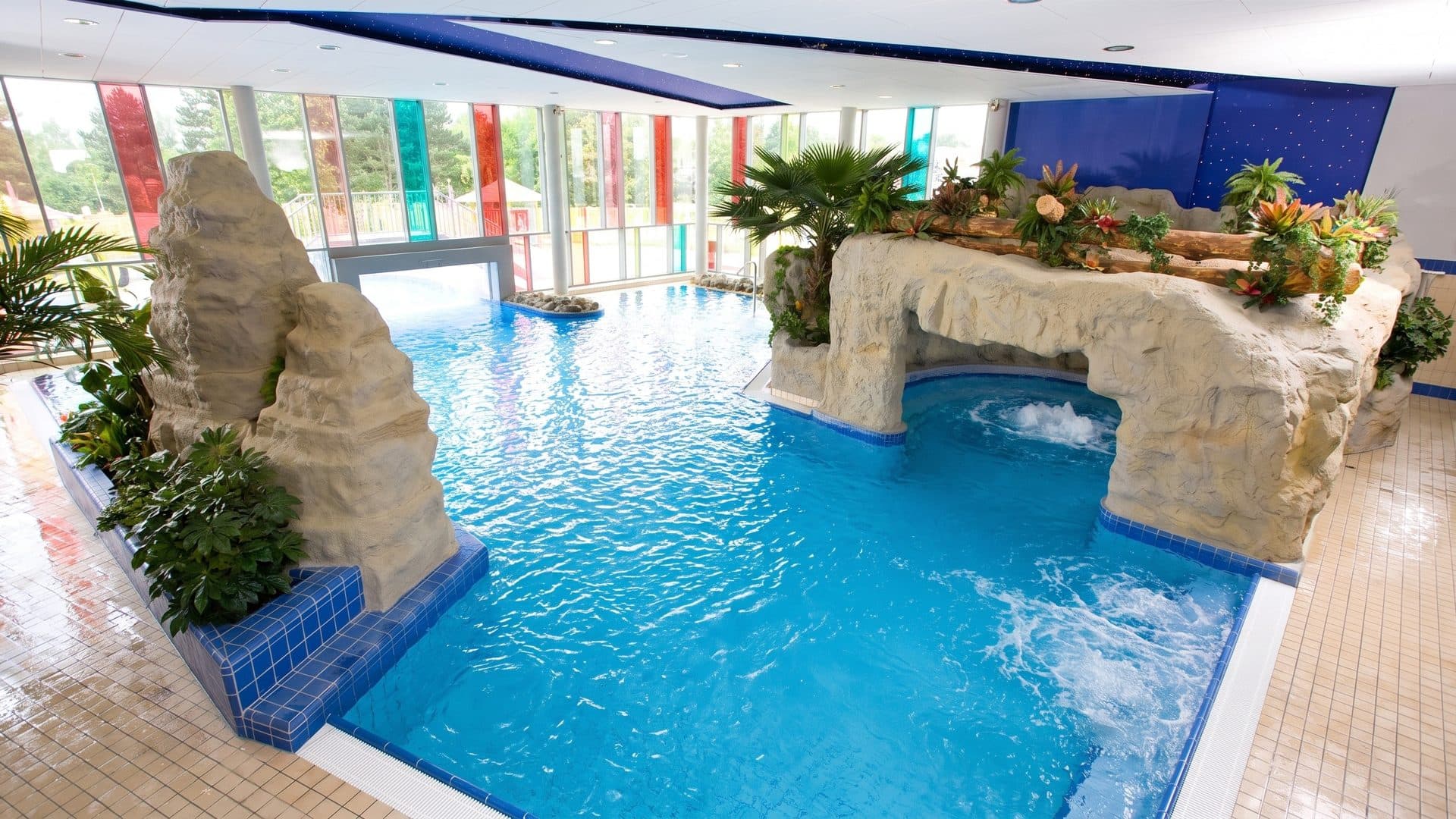 Indoor pool with artificial rock arches, planting and a bubbling grotto channel