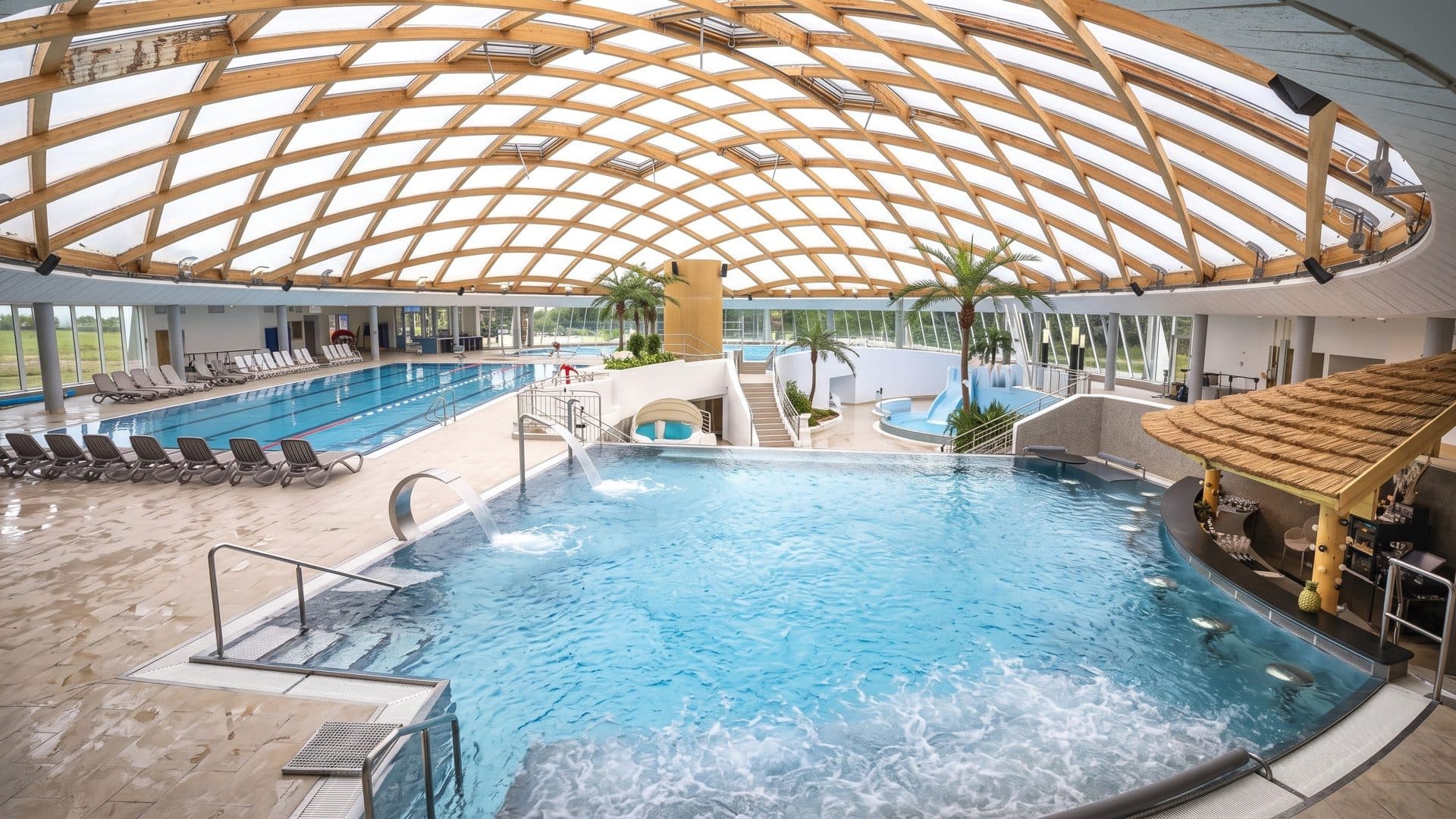 The whirlpool of elypso in Deggendorf under a timber lattice dome, lane pool behind