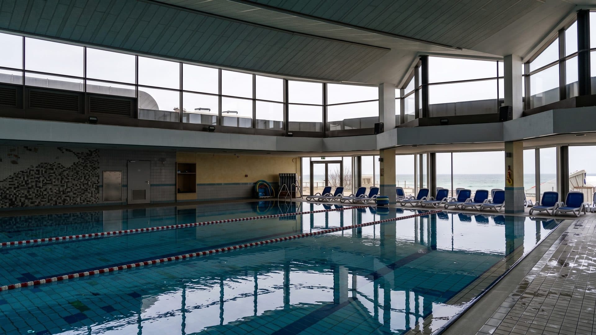 The indoor pool of the Entdeckerbad in Damp with a glass wall onto the Baltic and loungers along it