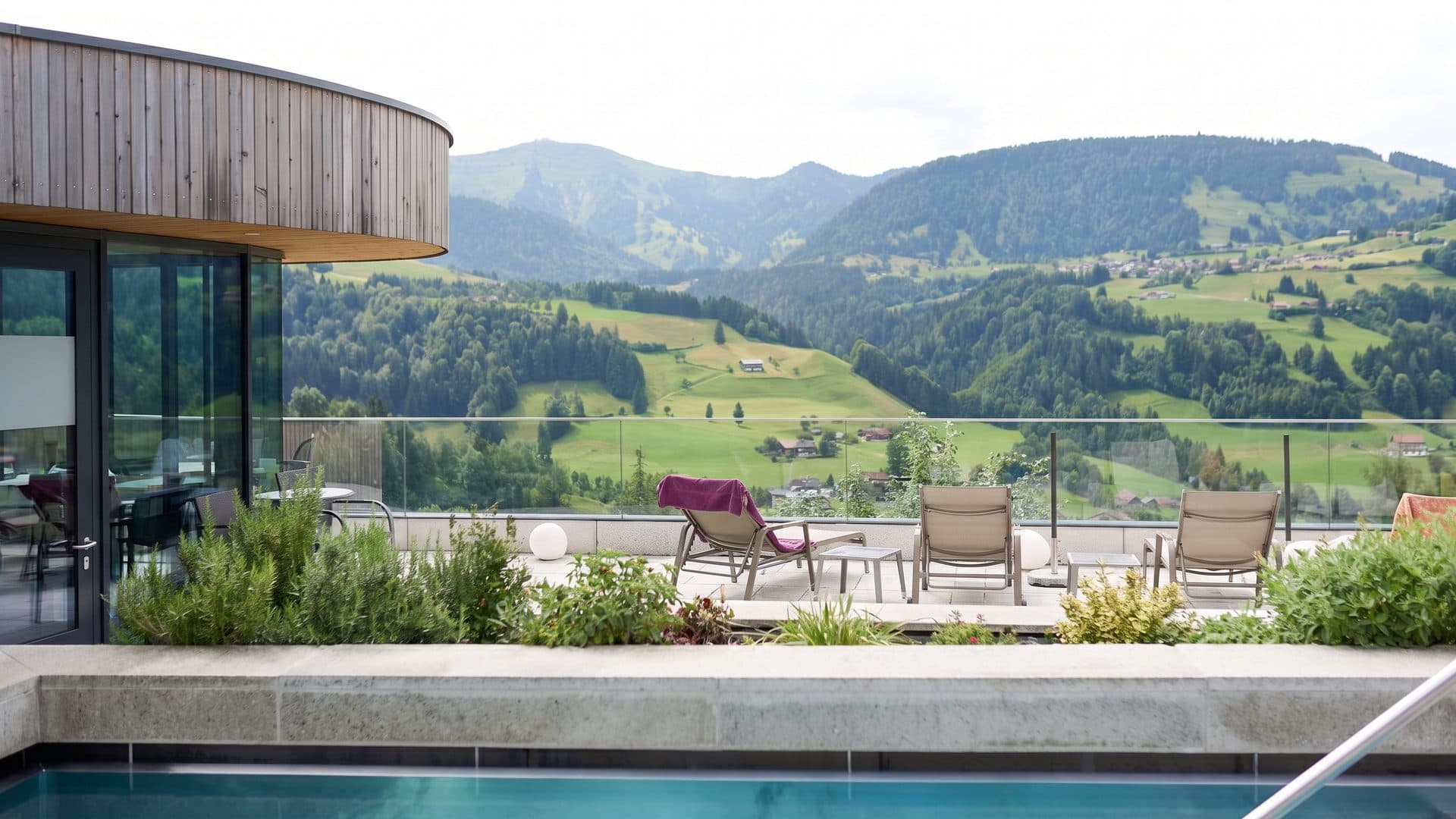 The terrace of Erlebnisbad Aquaria with loungers and planting looking out over the valley