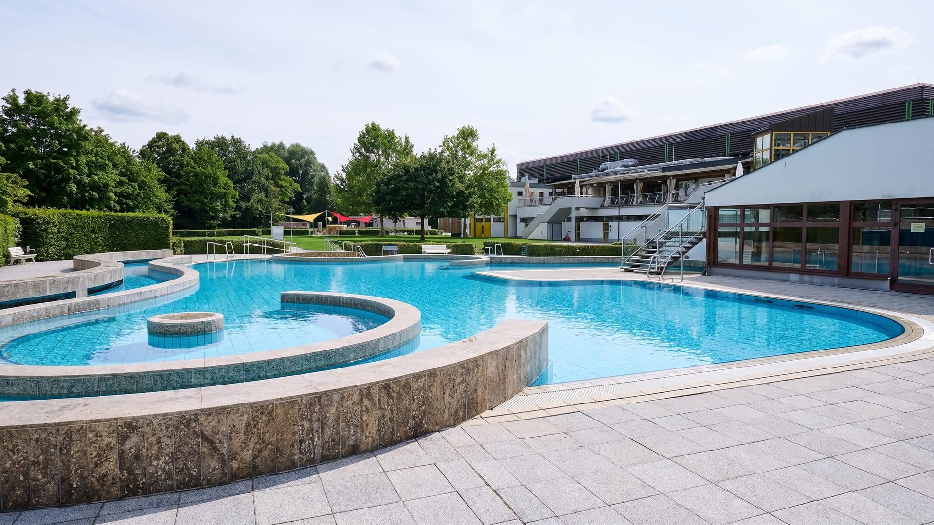 The outdoor pools of the Hassfurt leisure baths with the bath building behind