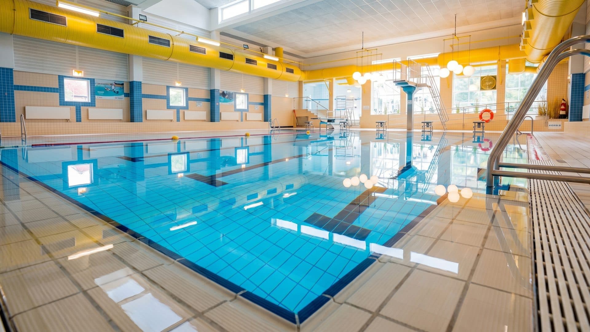 The lane pool of the Leck baths seen low across the water under its yellow hall
