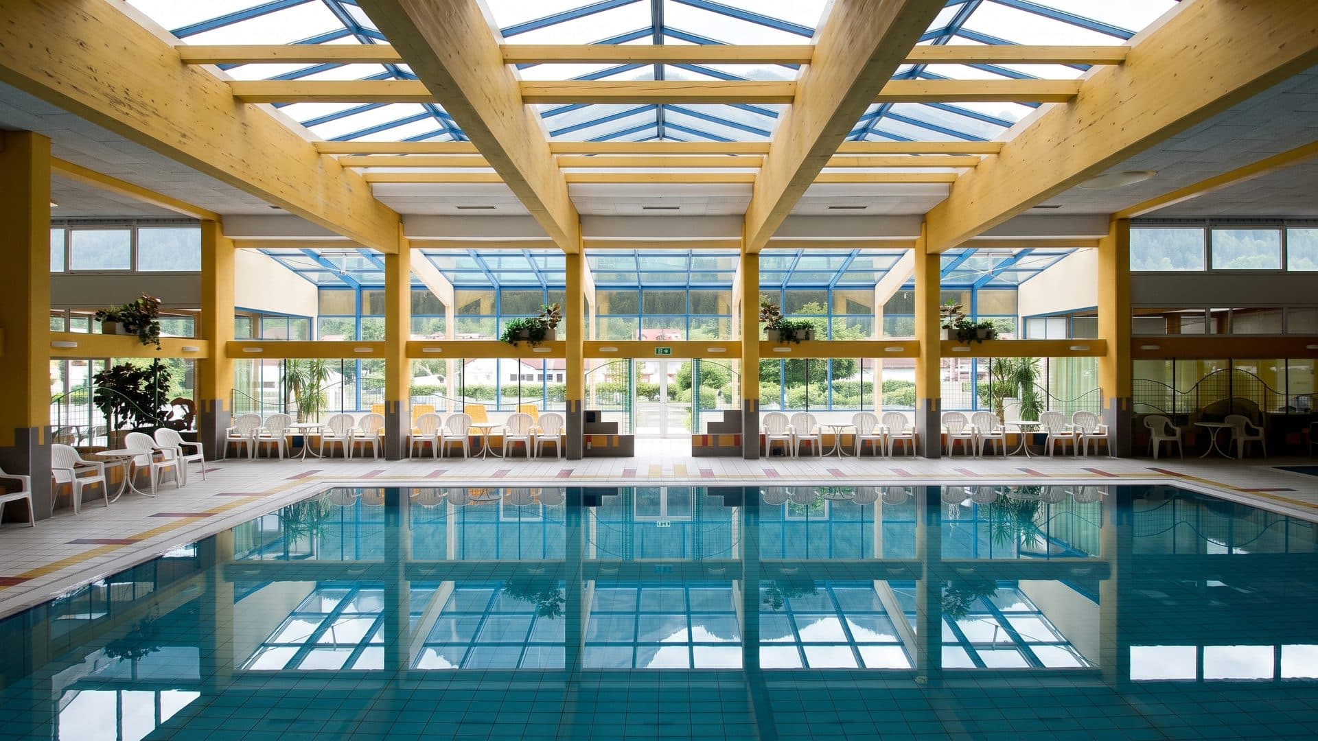 The pool of the Obervellach leisure baths under its timber roof beams