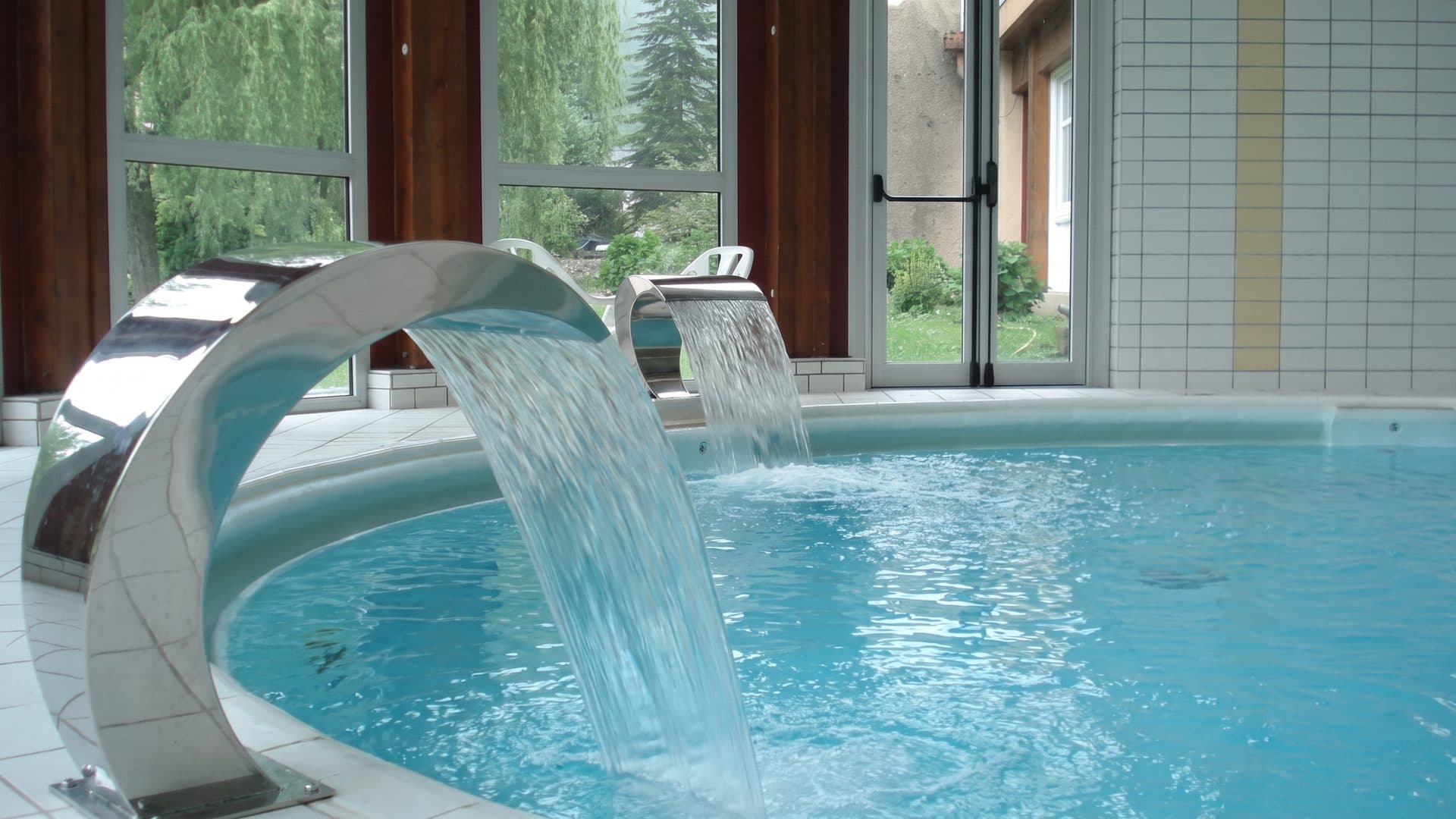 The cascade of the thermal establishment falling into its pool beside the window