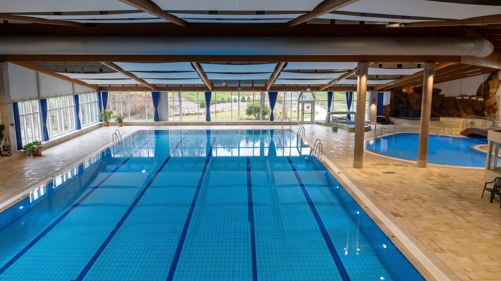 The indoor lane pool of PLUB in Pirmasens under timber columns and a panelled ceiling