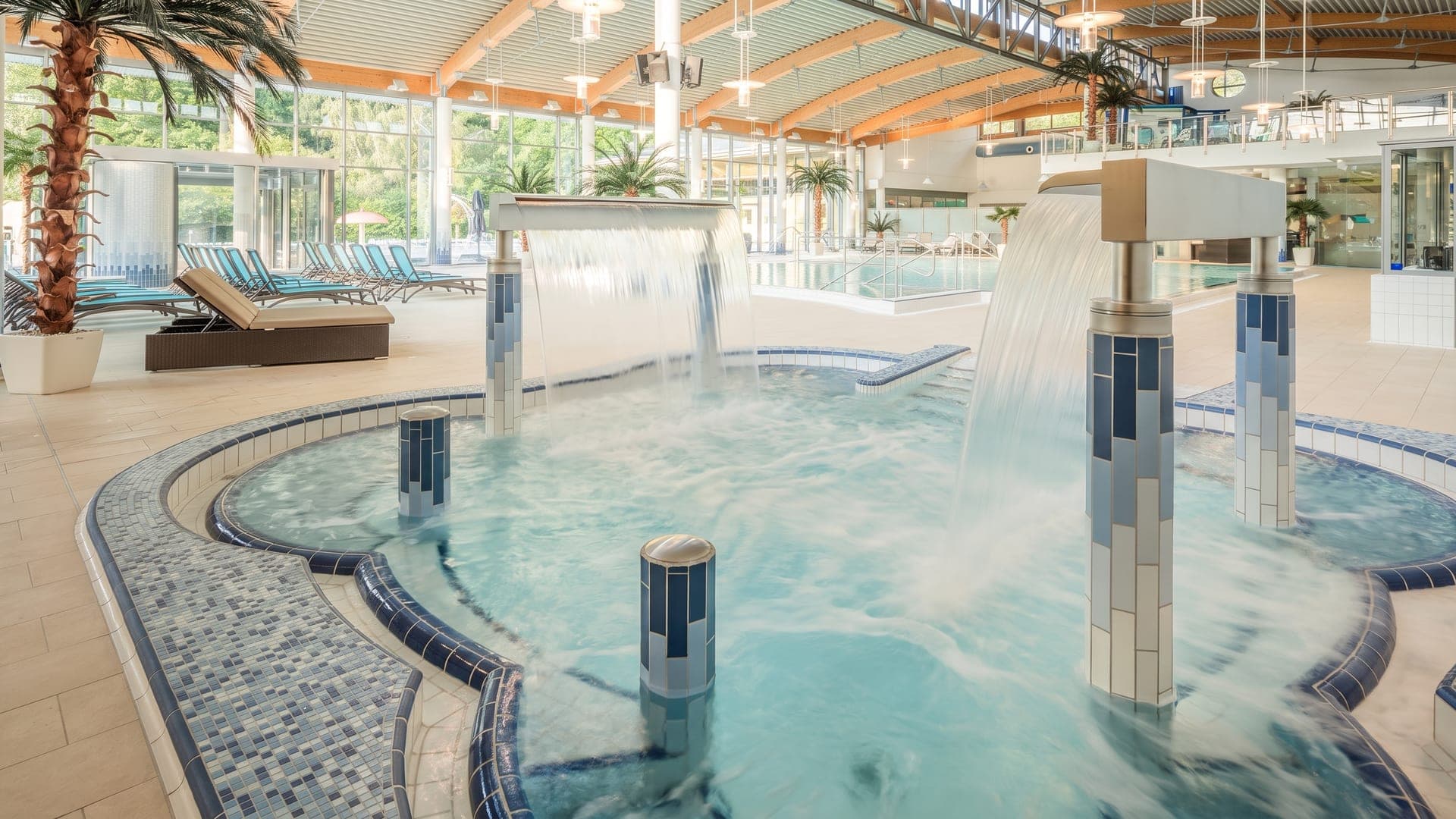 The indoor pool at the Friederiken Therme in Bad Langensalza, water falling from tiled columns into the bubbling basin.