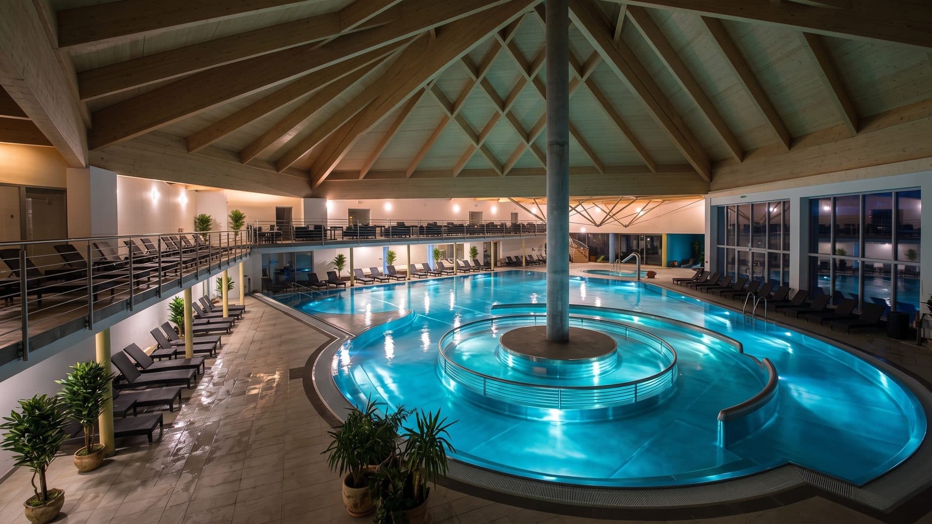 The indoor pool of Galandia winding around a central column under a tent-shaped timber roof