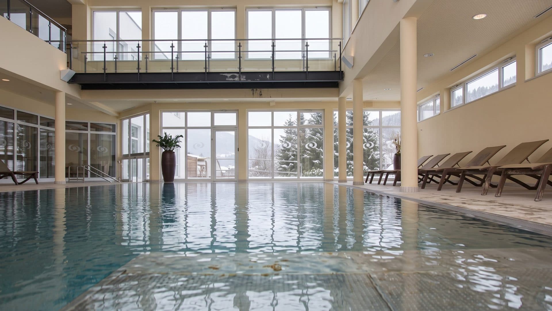 The indoor thermal pool of the OptimaMed Weissenbach resort in a bright hall with white columns and tall windows