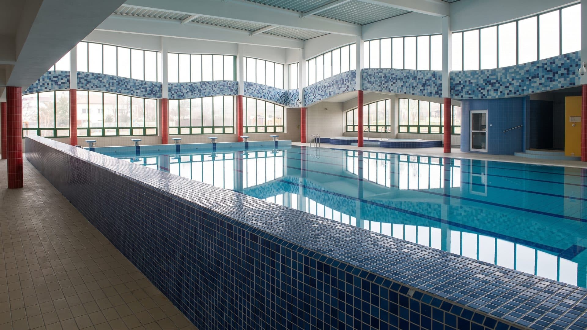 The pool hall of the Nautica centre with its blue mosaic surround and tall windows