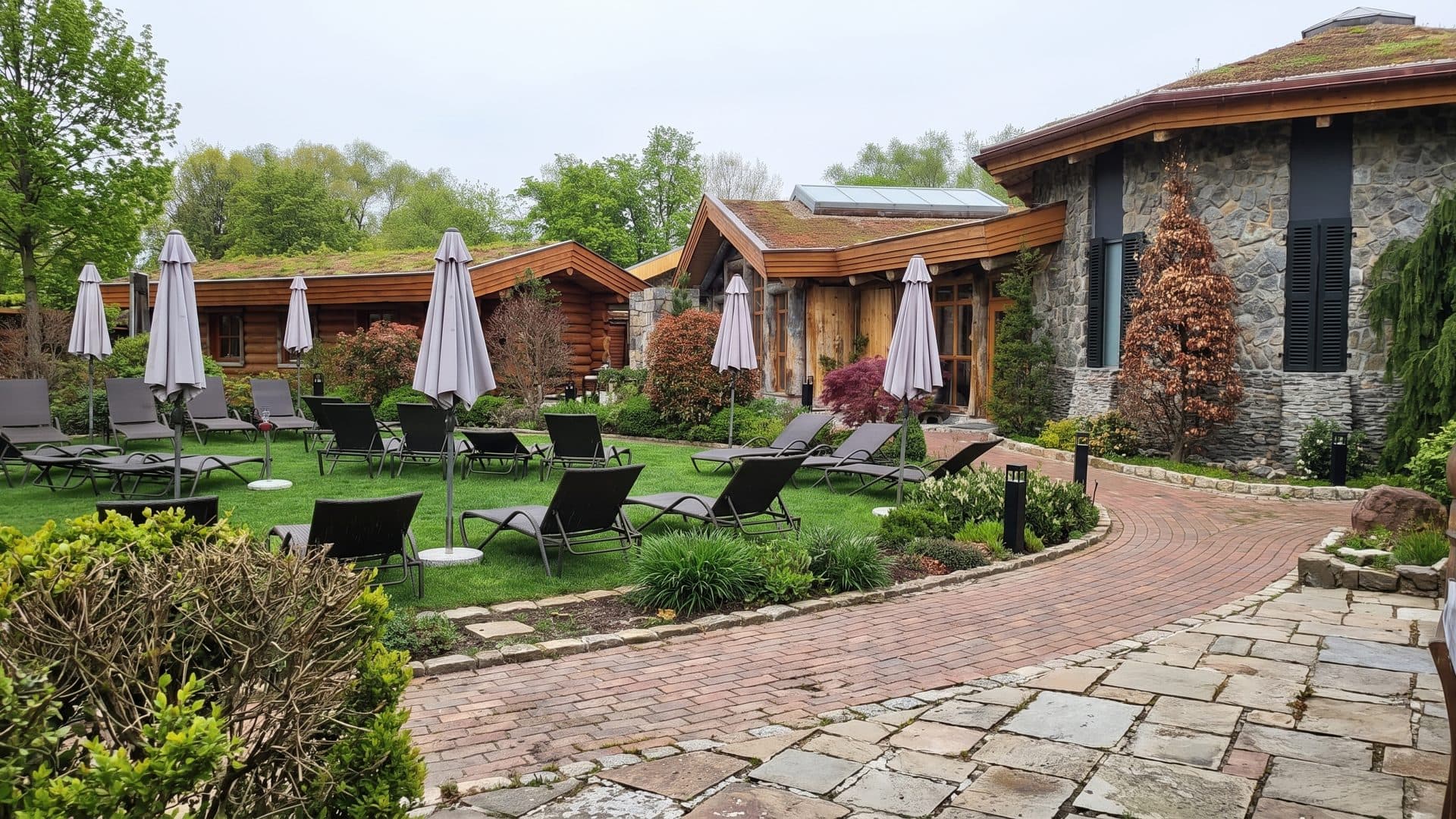 The bath's low timber-and-glass building behind a lawn of loungers and folded parasols.