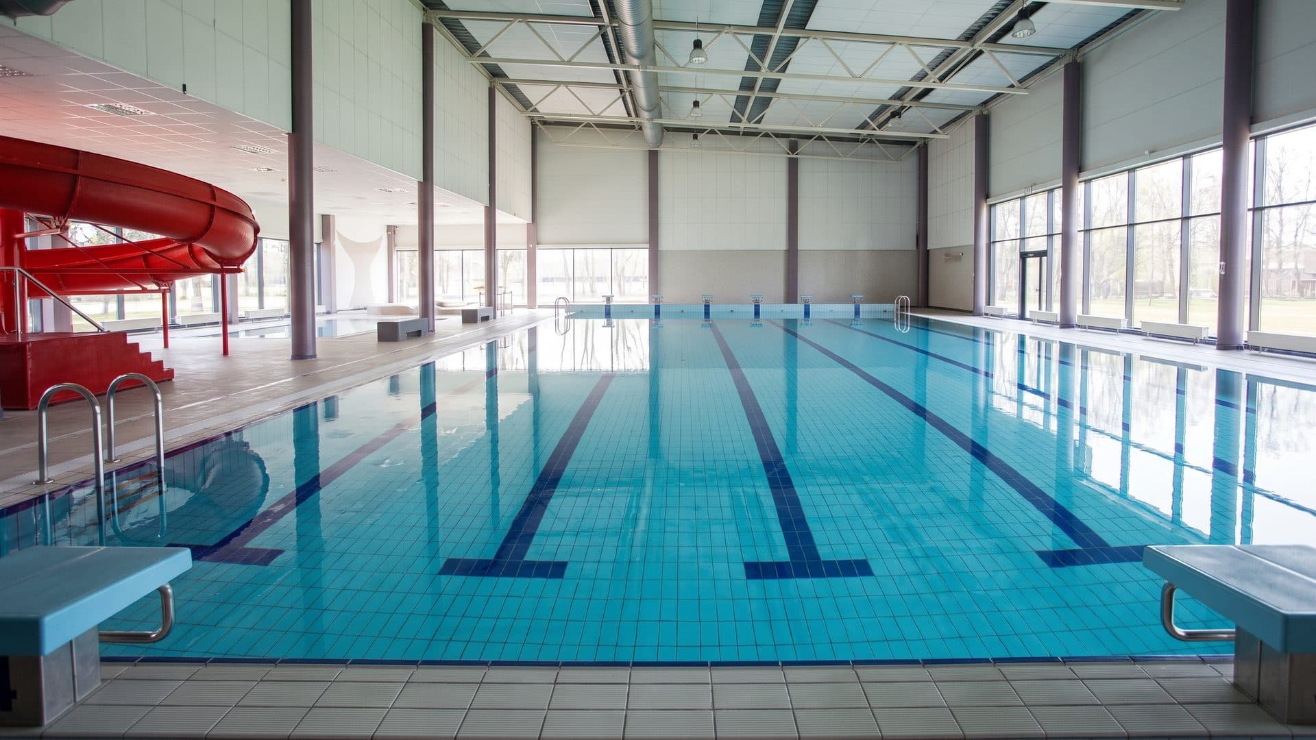 The pool of the Haapsalu water centre seen down its length with the slide beside it
