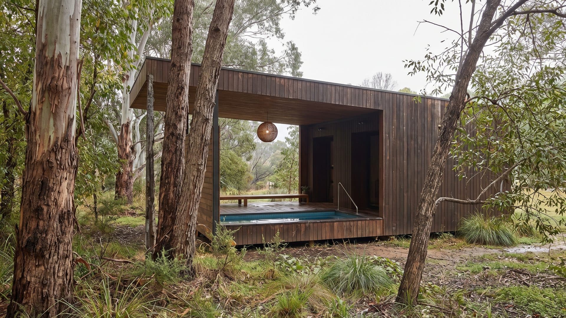 The timber bath pavilion at Hepburn Springs standing open-sided among the gum trees, its plunge pool inside