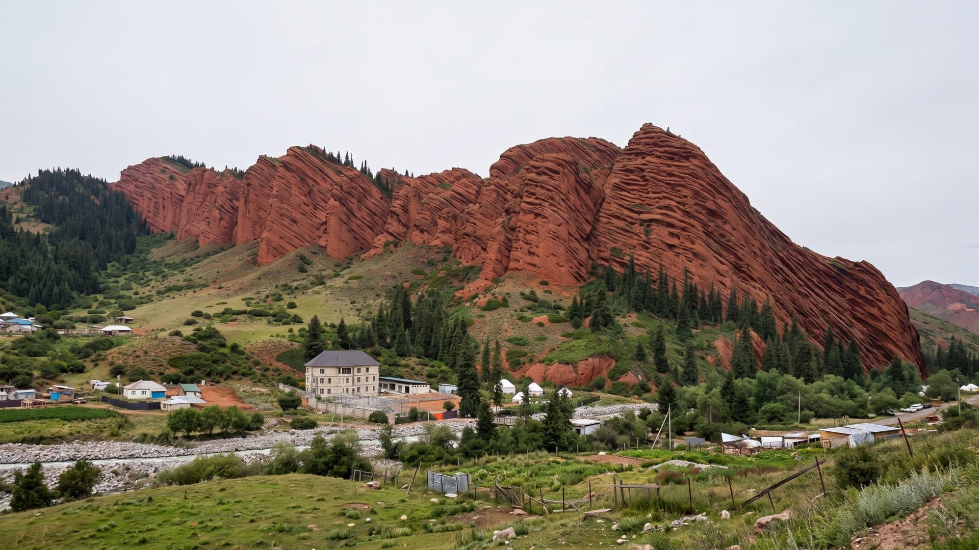 The red Seven Bulls rocks above the Jeti-Oguz sanatorium, with its buildings and meadow below