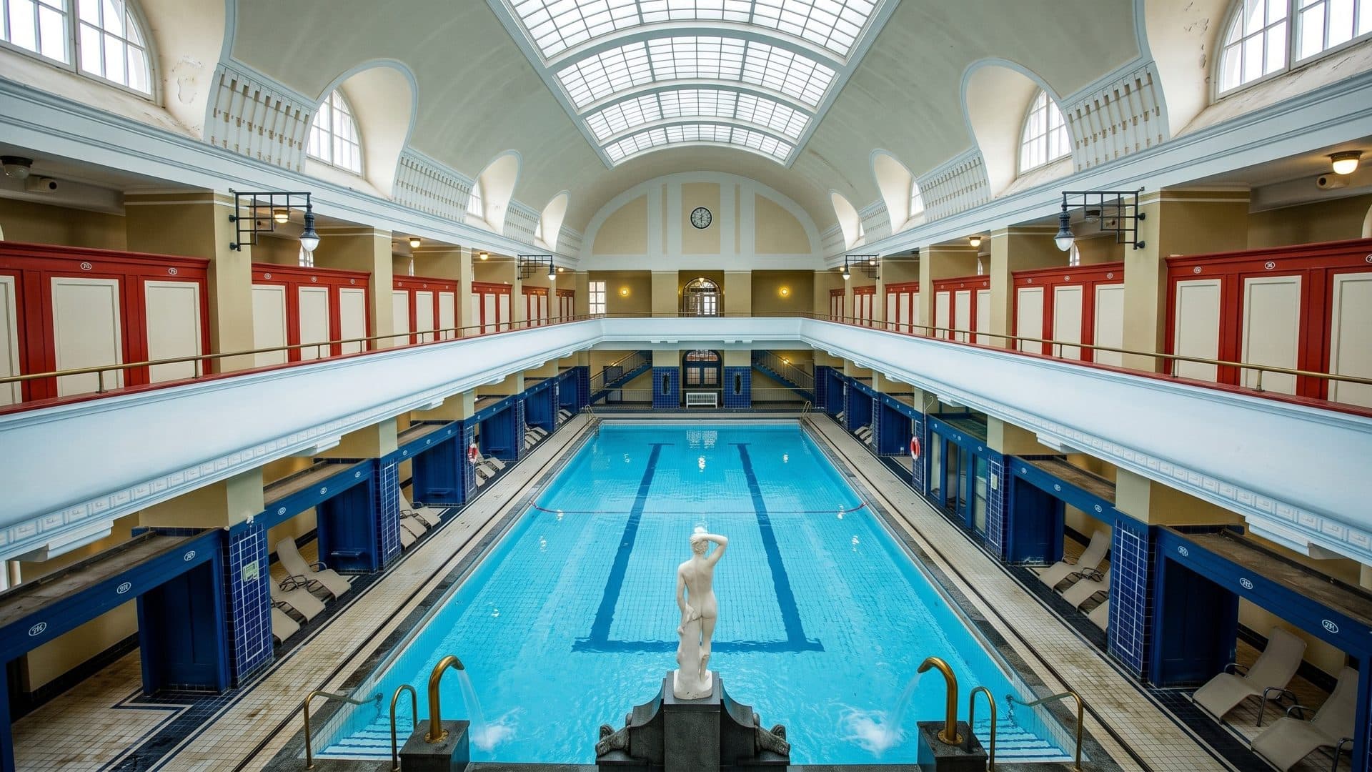 The Art Nouveau hall of the Jugendstilbad in Darmstadt with a statue at the end of the pool