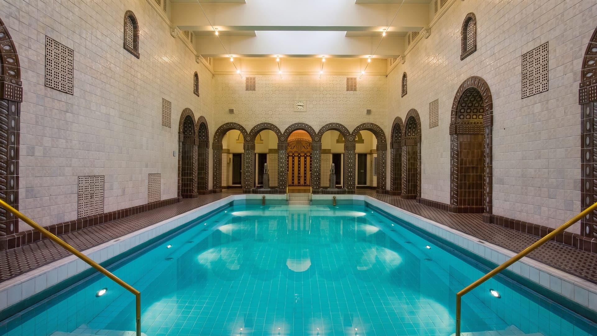Turquoise pool in the tiled Roman hall, ringed by arched niches