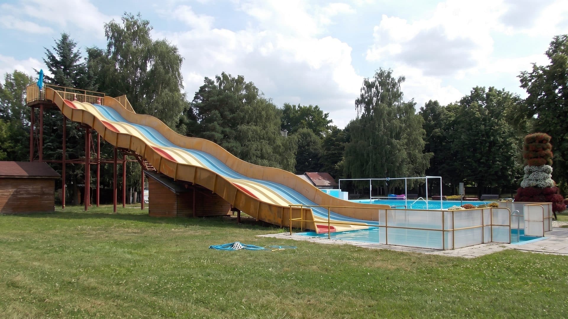 The coloured slide of the Kapuvár baths running down to its pool on the lawn