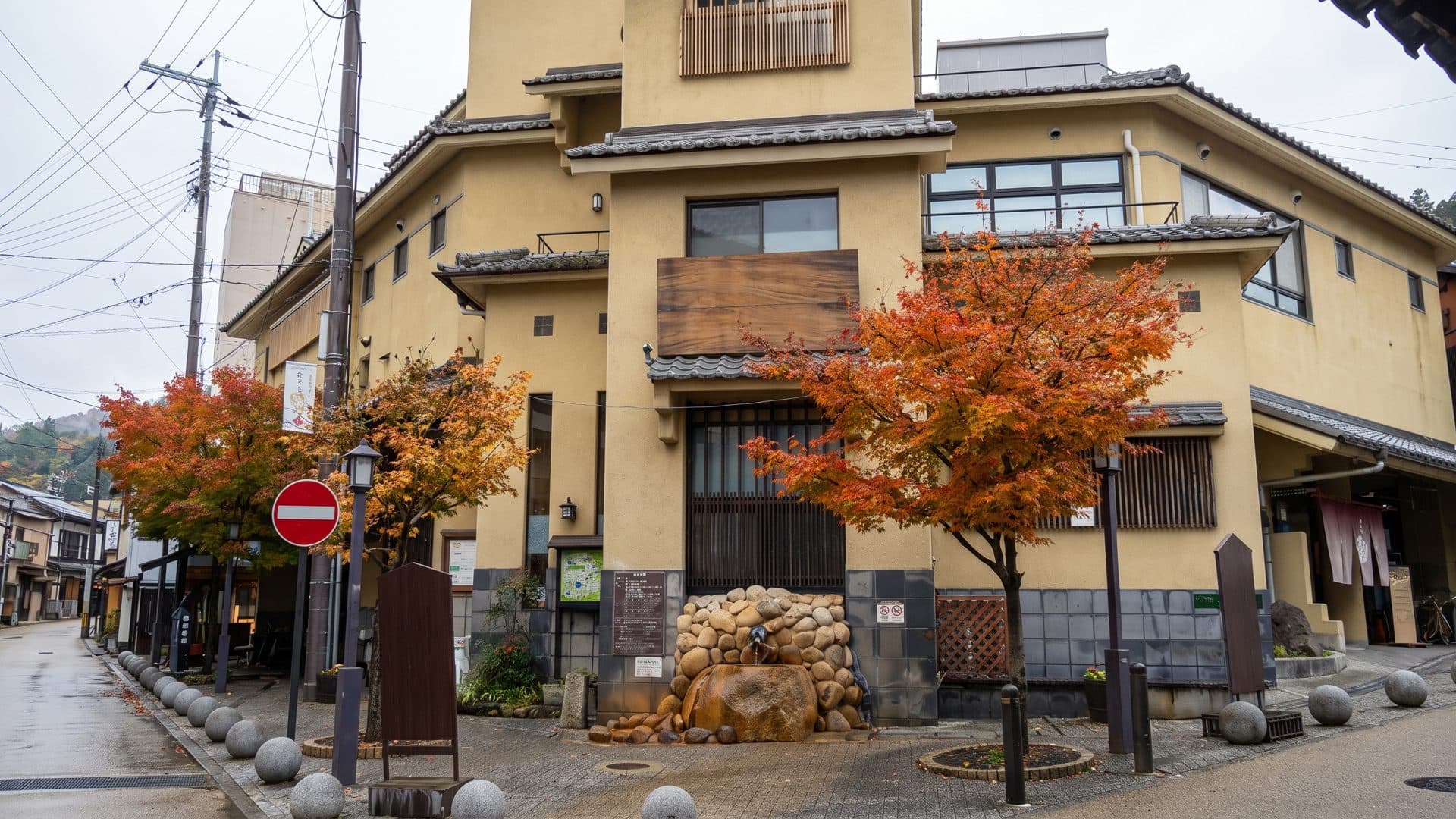 The Kin no Yu bath house in Arima Onsen seen along the street, with maples turning red in front of it