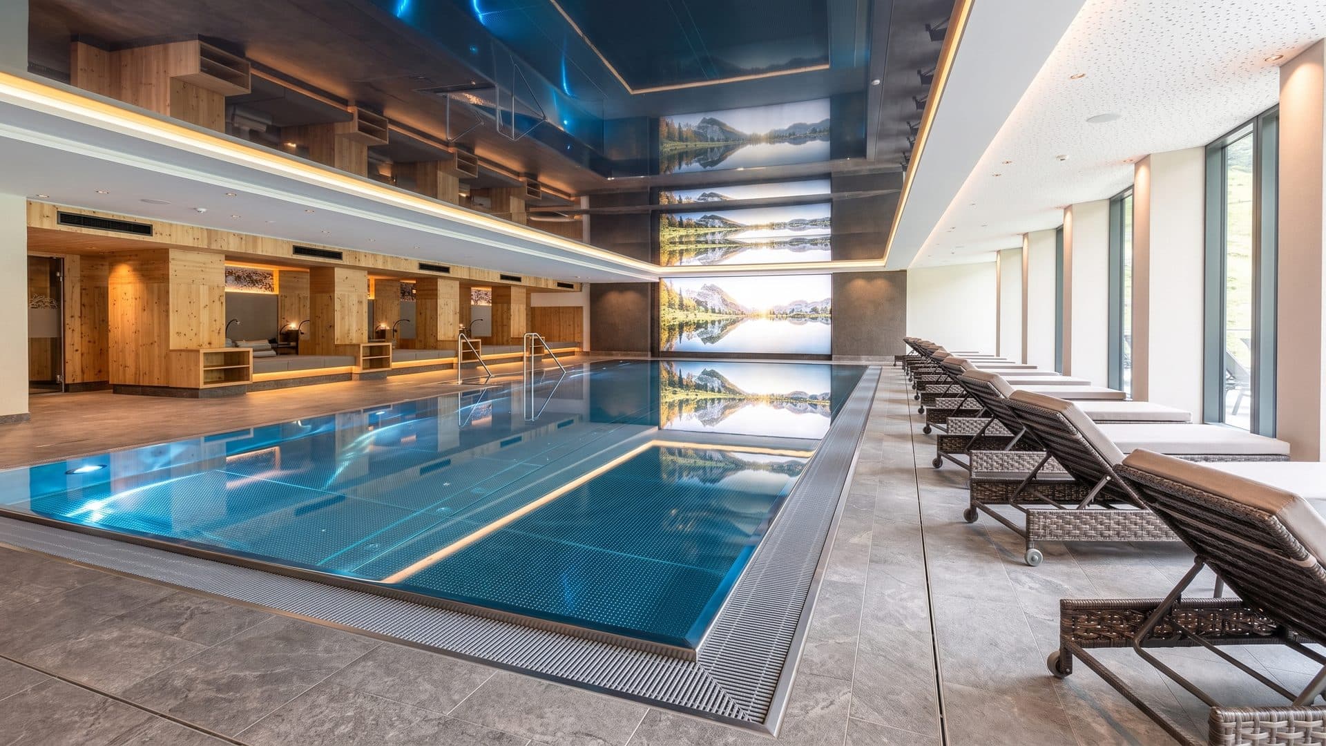 The indoor pool of the Kirchler spring baths along its loungers towards the mountain window