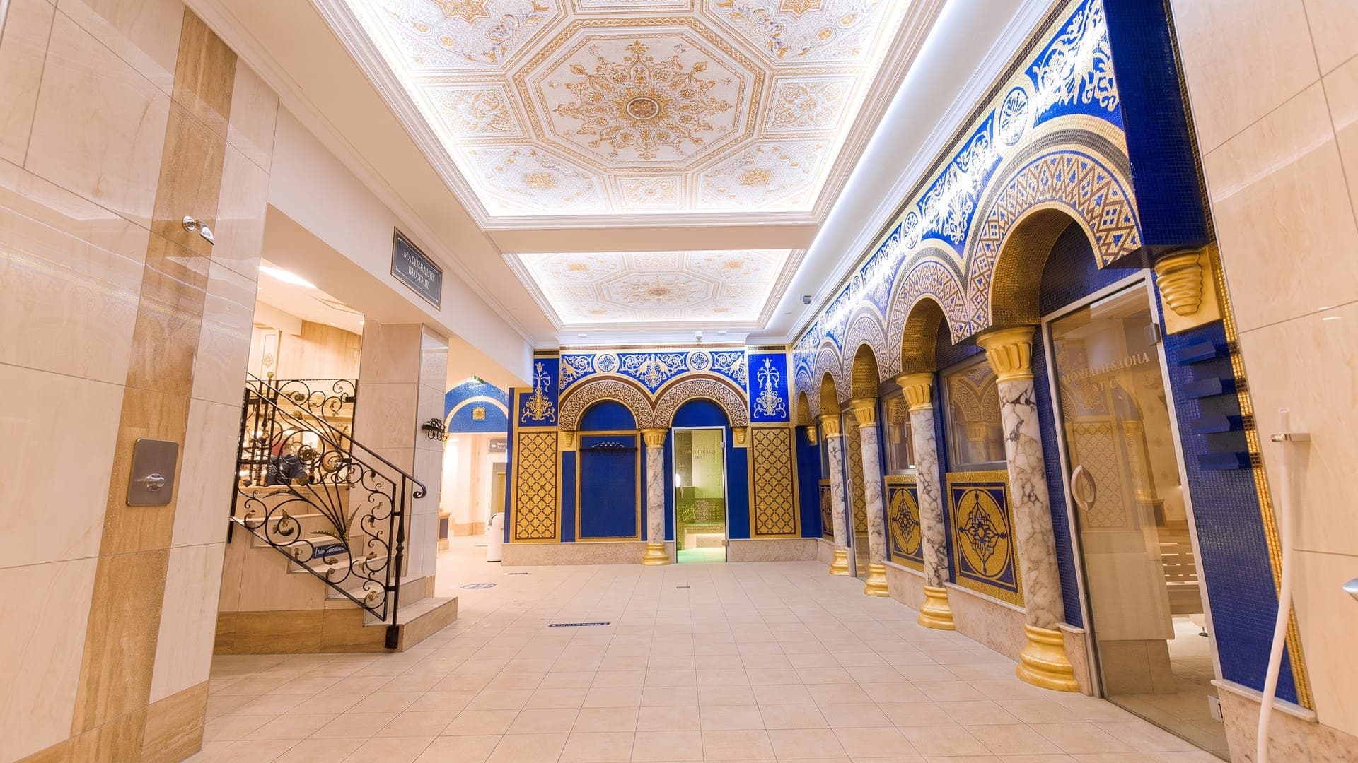 The Moorish-styled bathing hall at the Koenigliche Kristall-Therme in Schwangau, its arches set with cobalt and gold mosaic on marble columns.