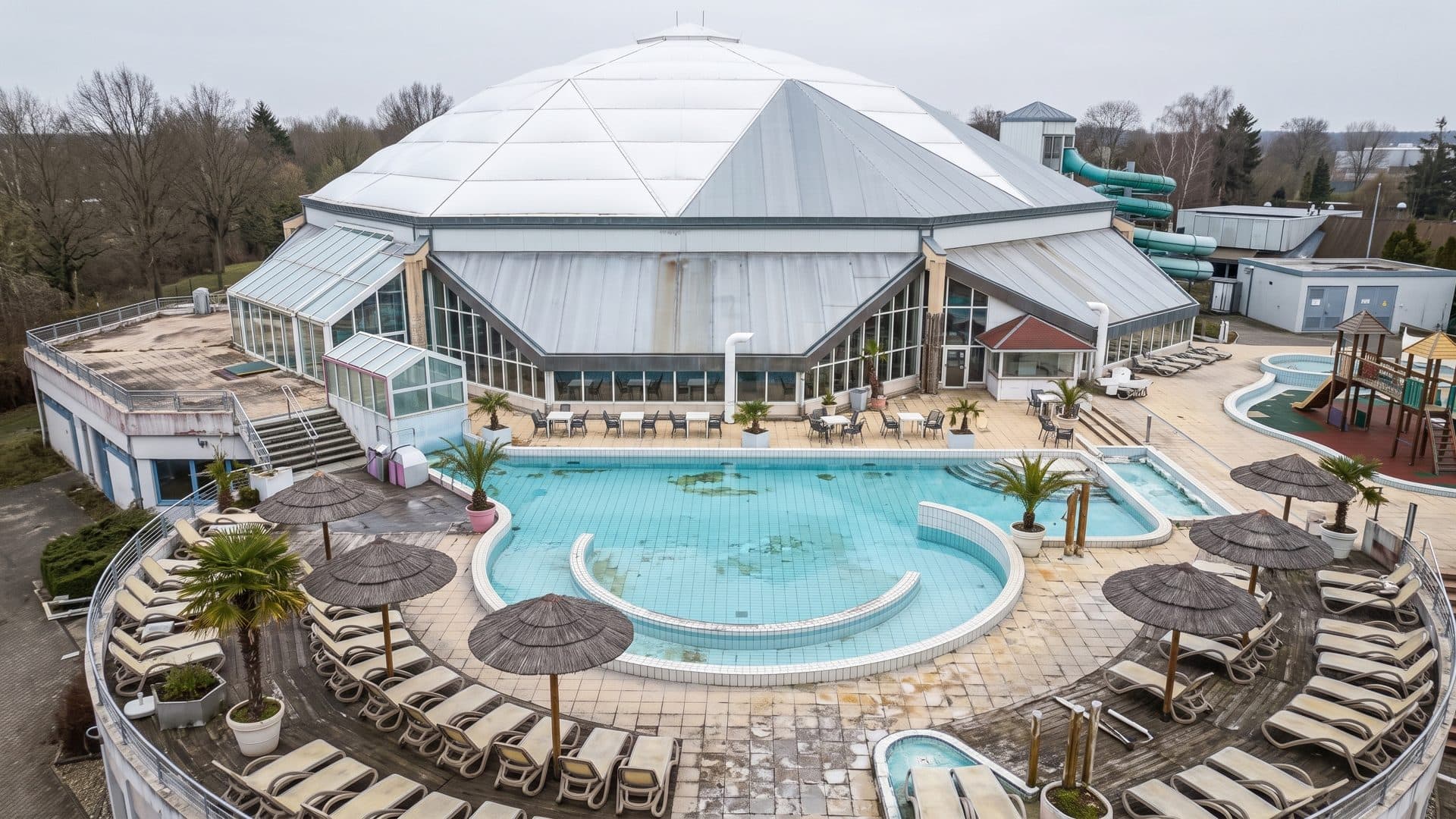 The baths from the air: the white tented dome over the hall, with the outdoor pool and palms around it.