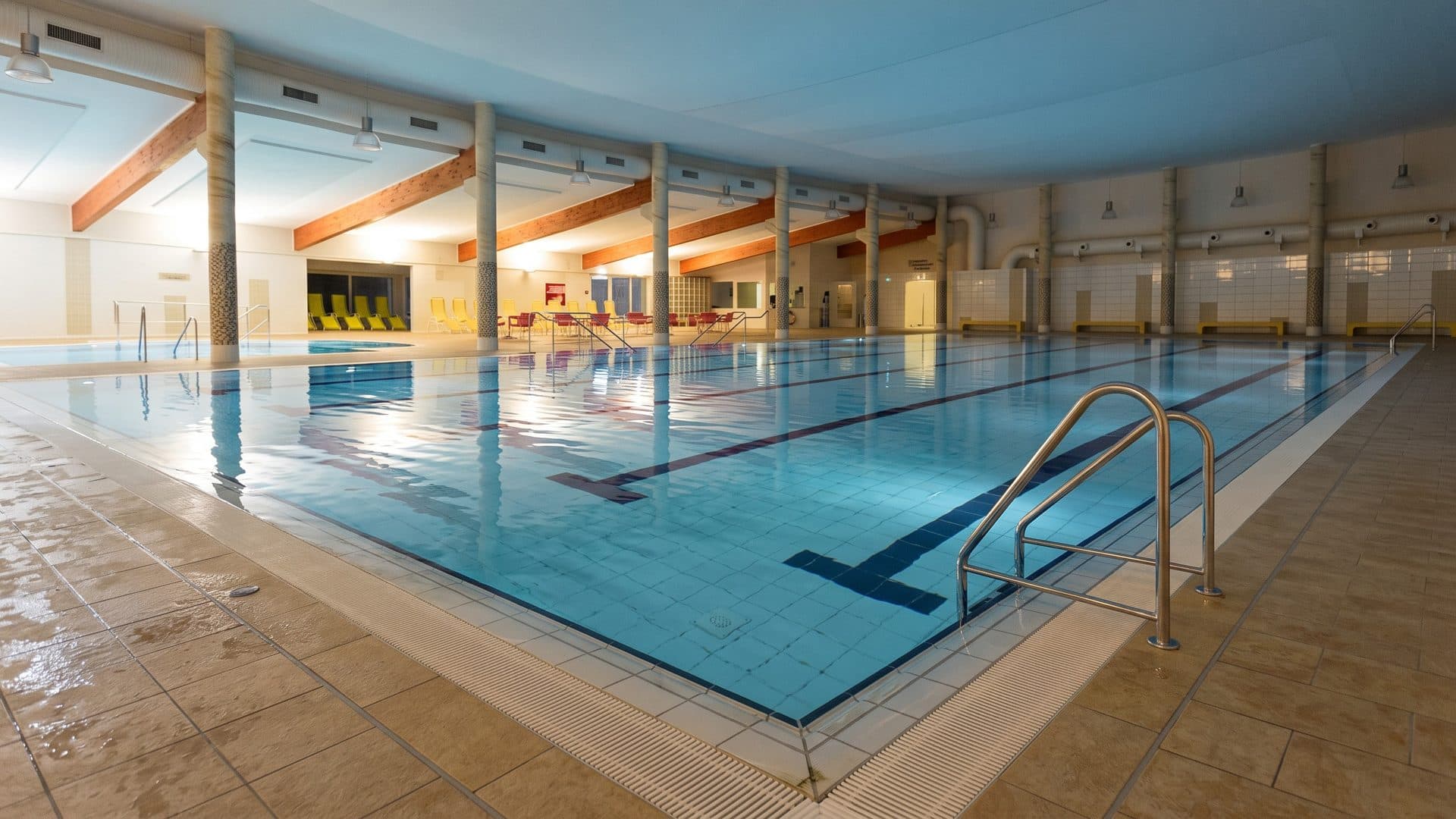 The lane pool of the Kubomare in Kuhlungsborn under a timber-braced roof, with orange walls along the hall