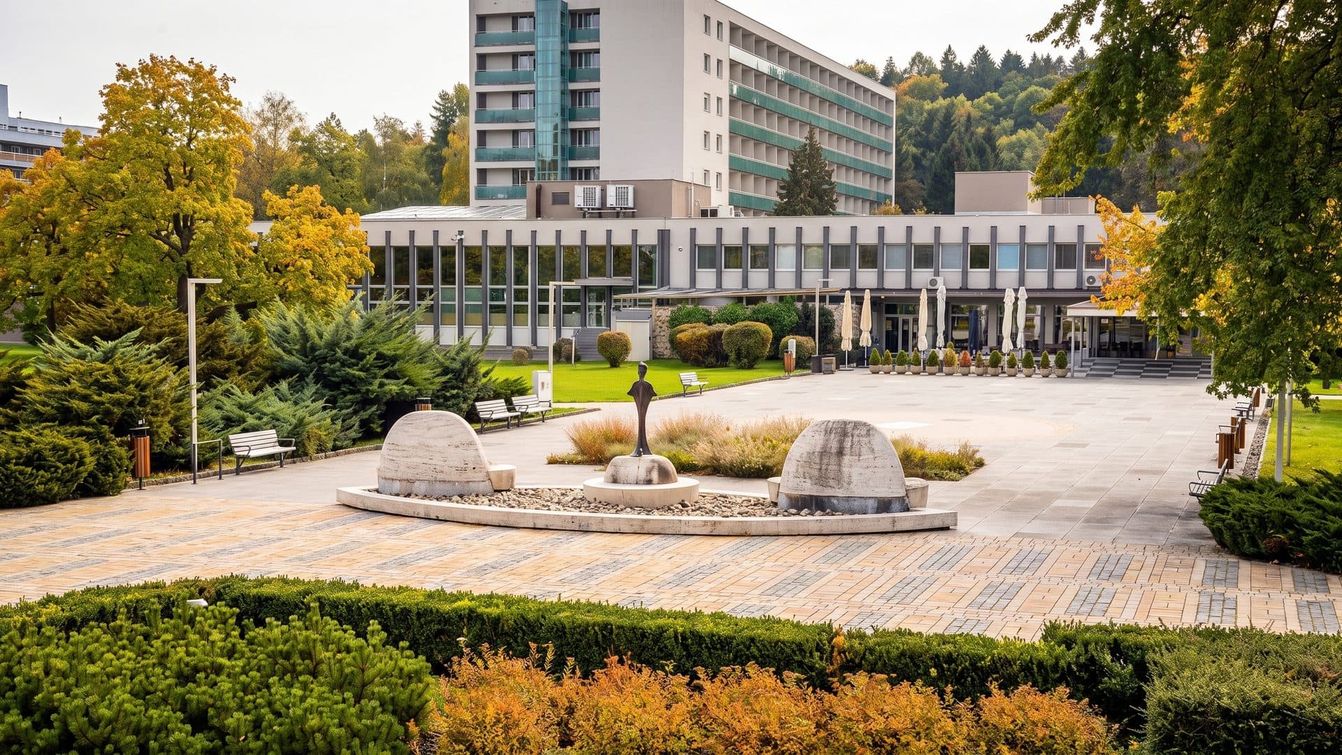 The courtyard of the Dudince spa with its domed pavilions, clipped planting and the spa building behind